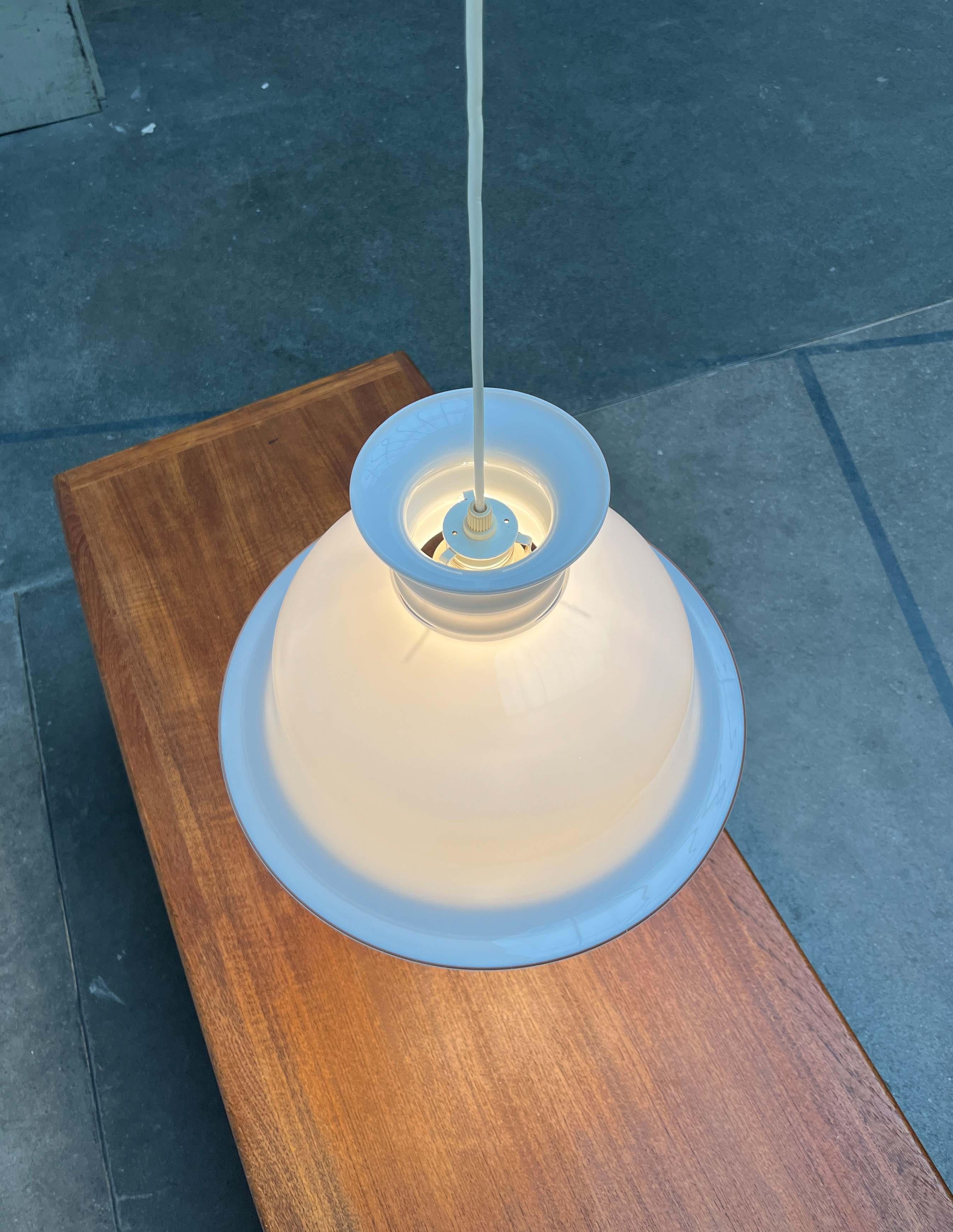 Lampada a sospensione in vetro ornamentale del produttore danese Holmegaard, disegnata da Sidse Werner all'inizio degli anni '80.

Un corpo di vetro rotante con sporgenze e rientranze sorprendenti funge da diffusore. Il vetro è trasparente lungo il