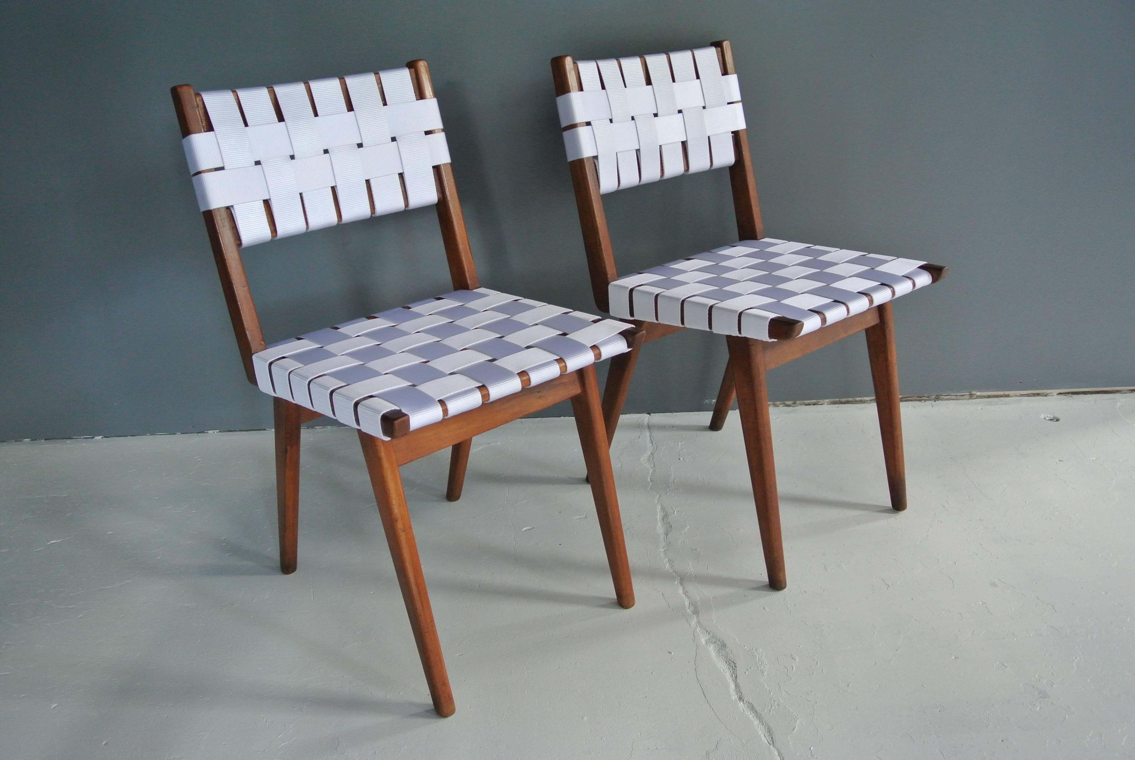 Newly refinished pair of early webbed side chairs by Jens Risom in walnut with white vinyl webbing.