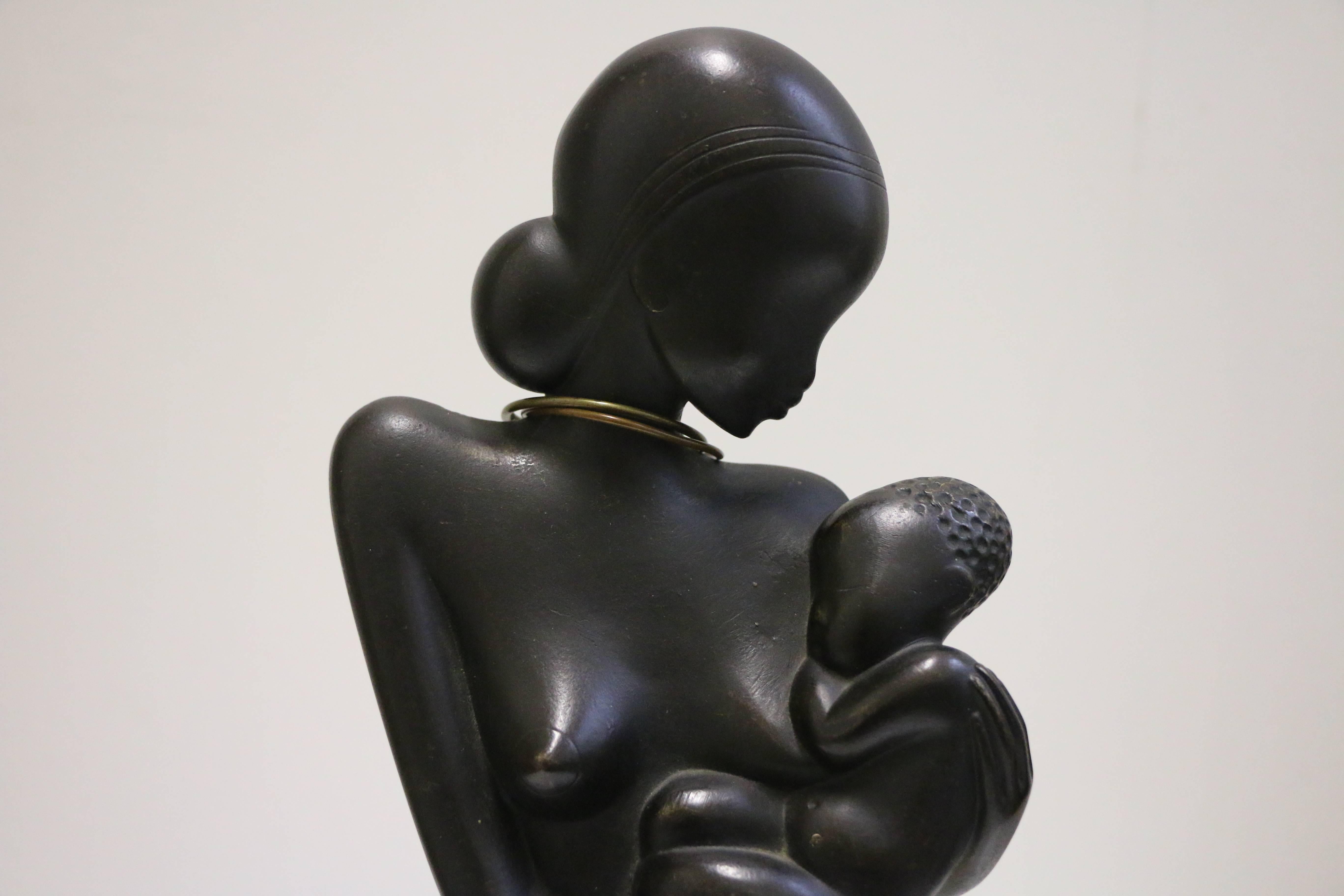 Art Deco sculpture representing a woman with a baby by Karl Hagenauer (1898- 1956). Bronze with dark patina, polished wood on a brass base. Stamp under the base: 