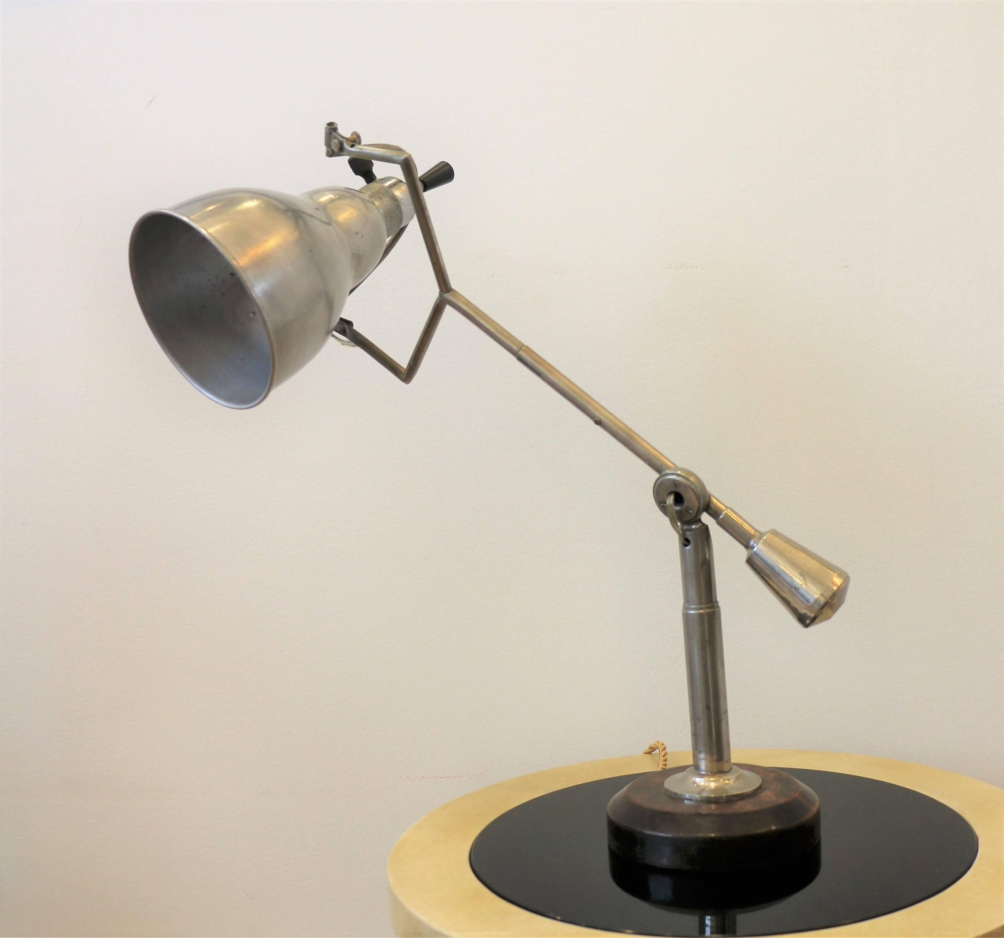This iconic lamp is an original one and was designed by Édouard-Wilfred Buquet (1886-?). It is an articulated lamp with one arm. It is balanced like a mobile with an adjustable counterweight. It is made of aluminium (for the shade), nickel-plated
