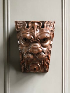 An English carved oak lion mask panel, 19th century, in the 17th-century manner