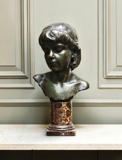 Un busto de bronce patinado de una niña, de alrededor de 1900
