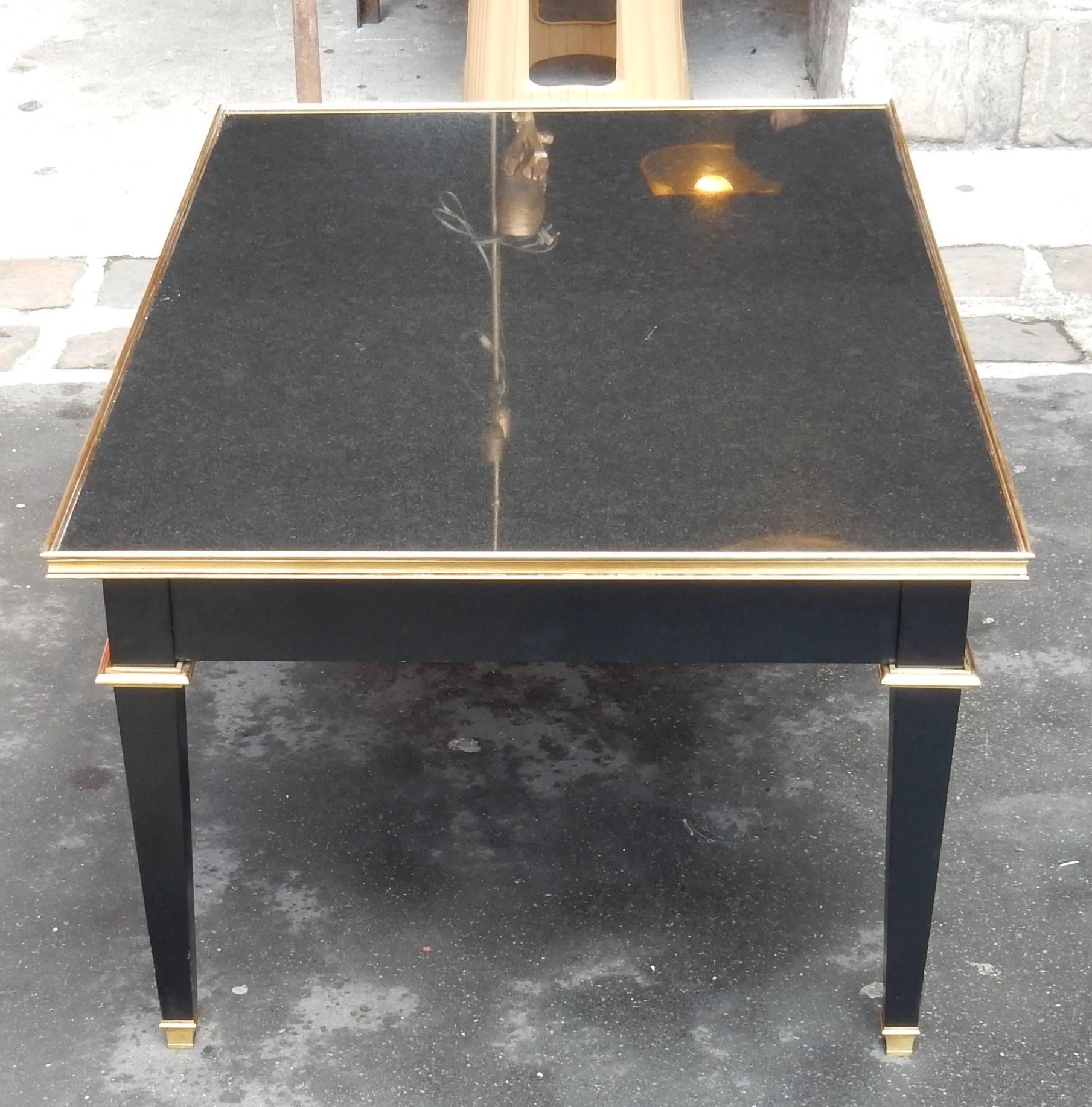 Wooden black lack coffee table covered with a black granite from Zimbabwe with the same grain as Porphyry.
Feet sheaths adorned with bronze bushings and hooves and the tray belt.