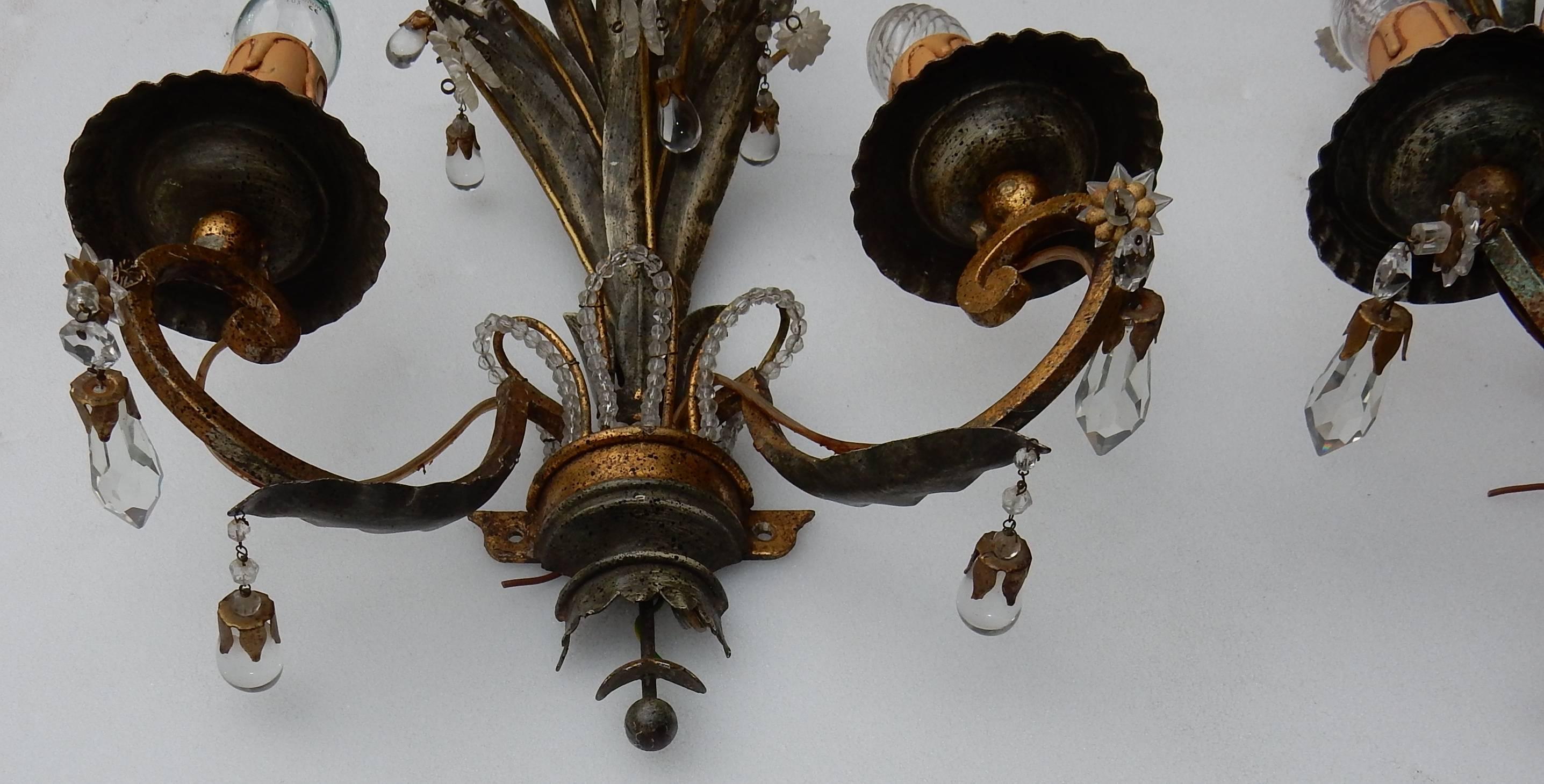 Pair of sconces with leaves of pineapple and crystals and two-light arms, iron gilded and patined, condition of use, circa 1950-1970.