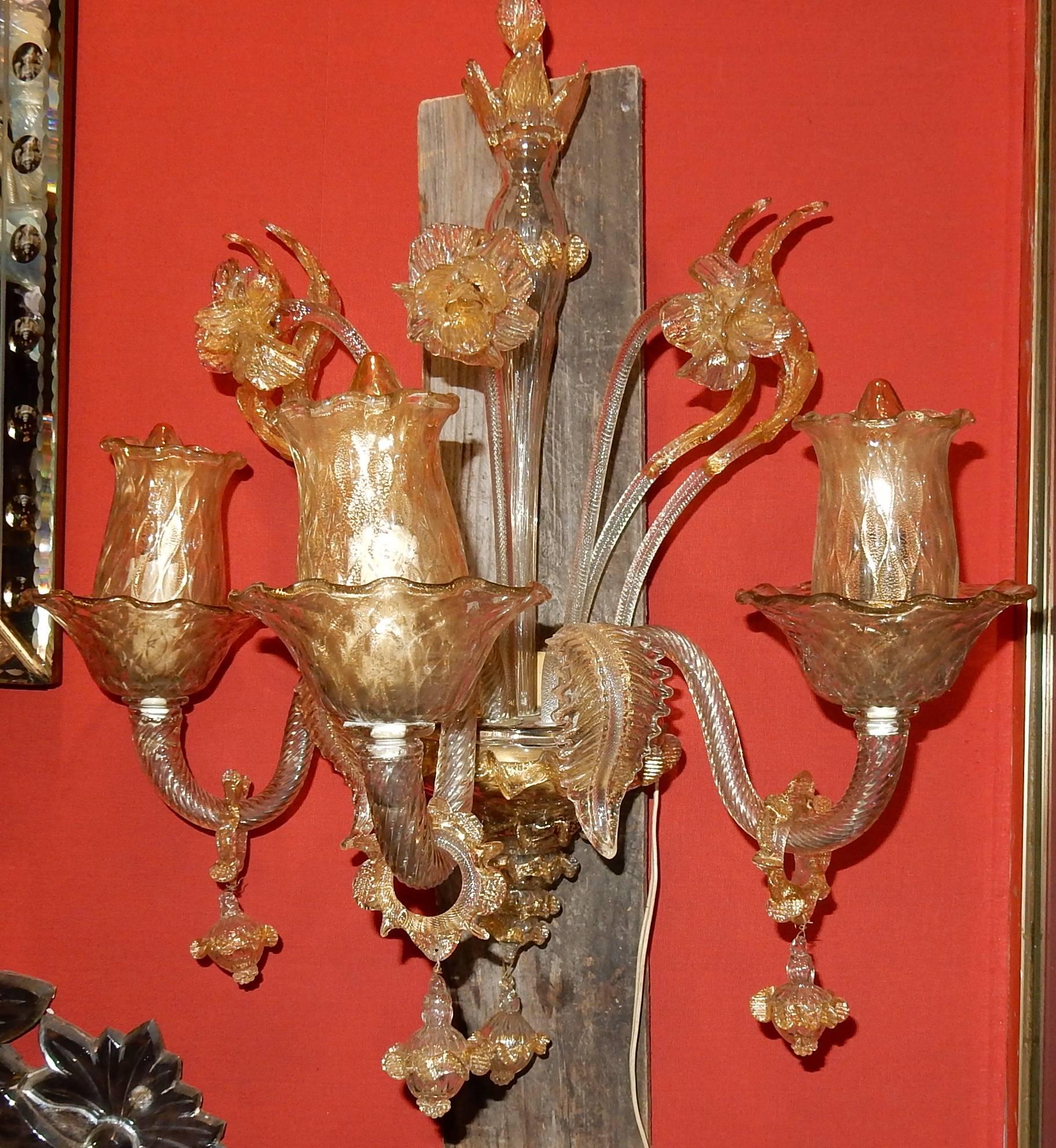 Wall lamps three arms, one torch, two falling leaves, three rising flowers, four rising leaves, rings and bells, lower cone ending in bell, good condition.