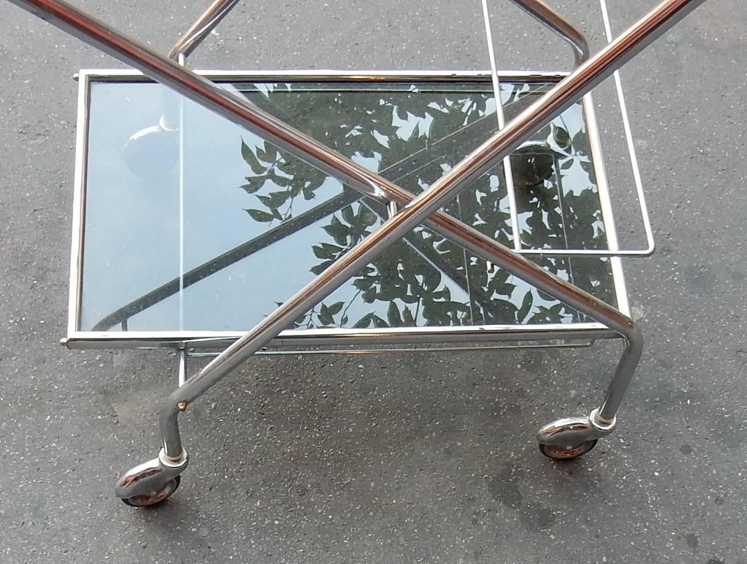 Metal folding rolling bar chrome-plated with galery , conceived for the journey, this bar complies and occupies dimensions:50 x 30 x H 91 cms, two smoked trays
everything is screwed.
Good condition, circa 1970.