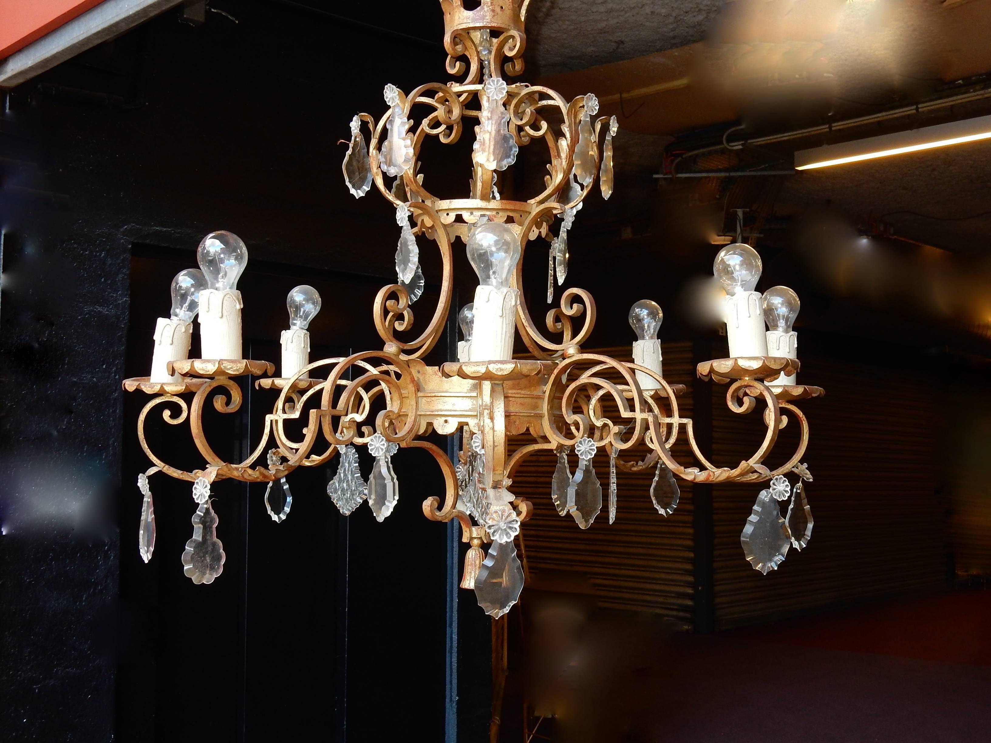 Chandelier of wrought iron medieval style, everything is screwed and welded, eight arms of light, the measures are without the chain, approximately 1 meter more , eight bulbs and four in the centre, crystal pendants, circa on 1950, condition of use.