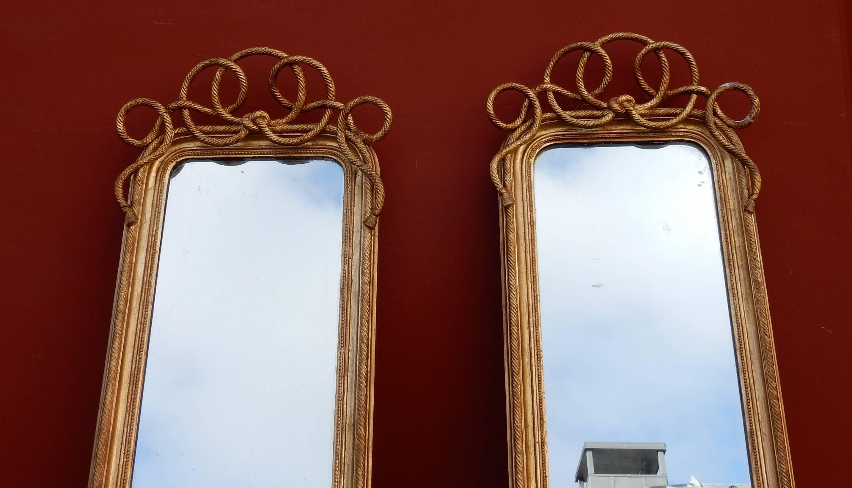 Paire de miroirs dans un cadre en bois et décorés de moulures en stuc doré à la feuille. Les miroirs sont  dans le mercure, période N 3,   2m21 x 0m47 je ne sépare pas cette paire 