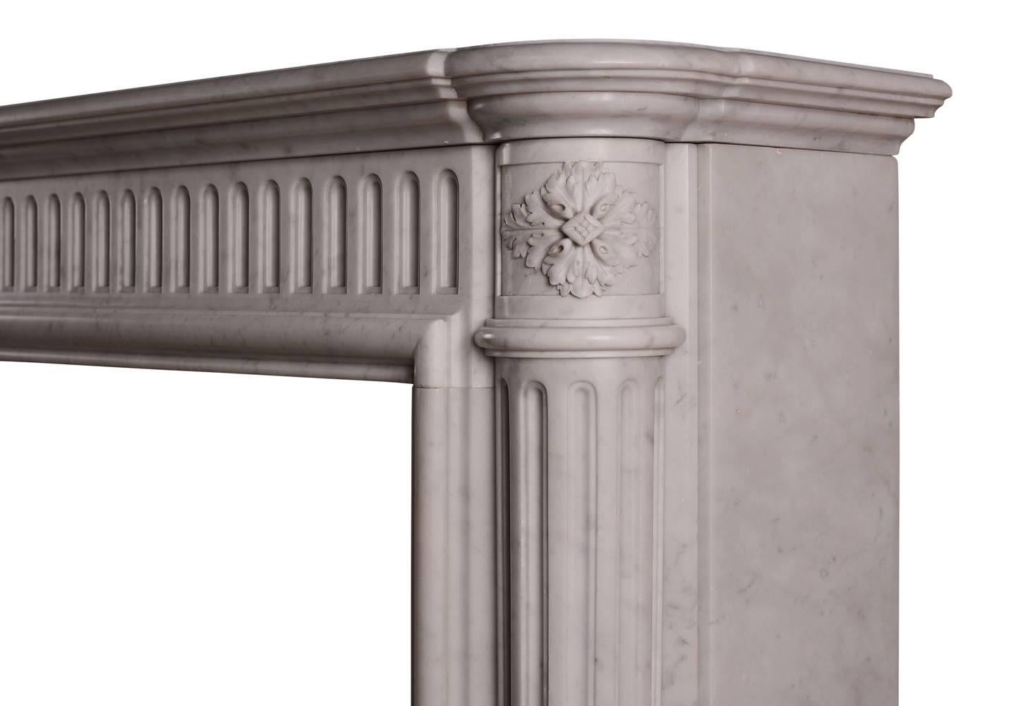 An unusually tall French marble fireplace in the Louis XVI manner. The elegant jambs with tapering, fluted columns surmounted by carved capitals, the frieze with fluting throughout surmounted by moulded shelf above. 19th century.

Shelf Width - 1285
