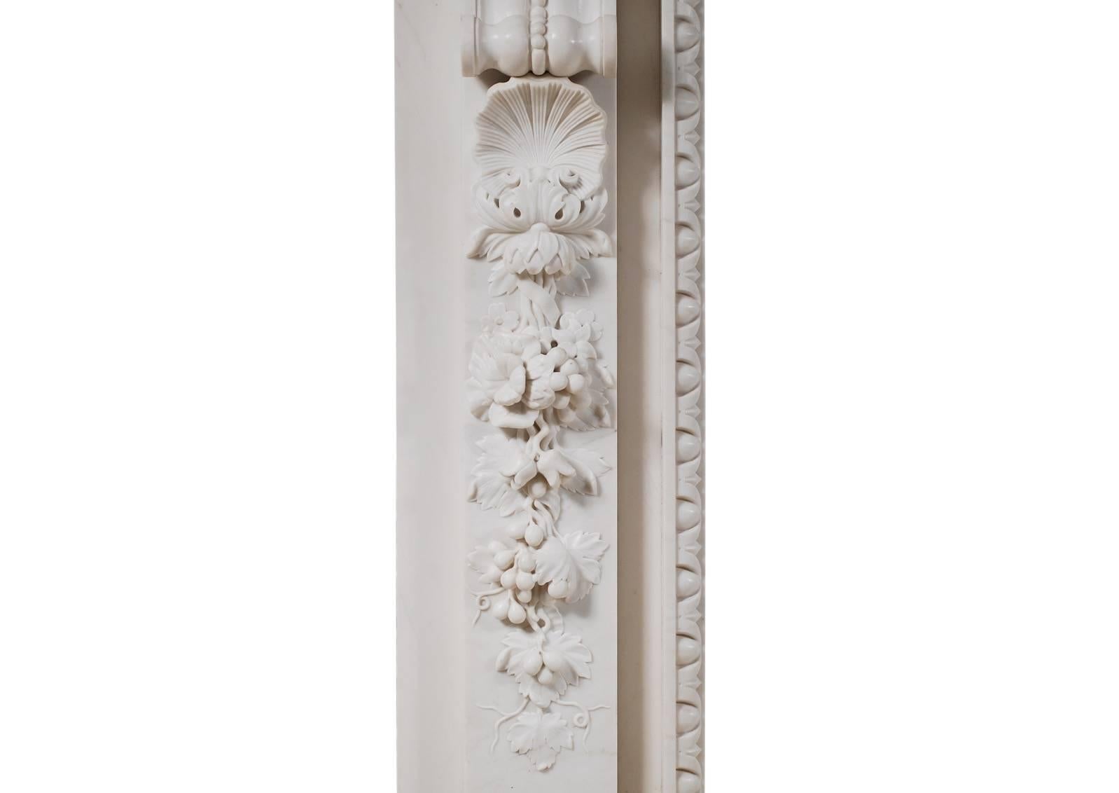A mid-Georgian style fireplace in white marble, the carved tablet illustrating Aesops fable. The Dog and the shadow. The jambs with deeply carved shell and drops of vine leaves, grapes and foliage with tied ribbons, surmounted by scrolled brackets.