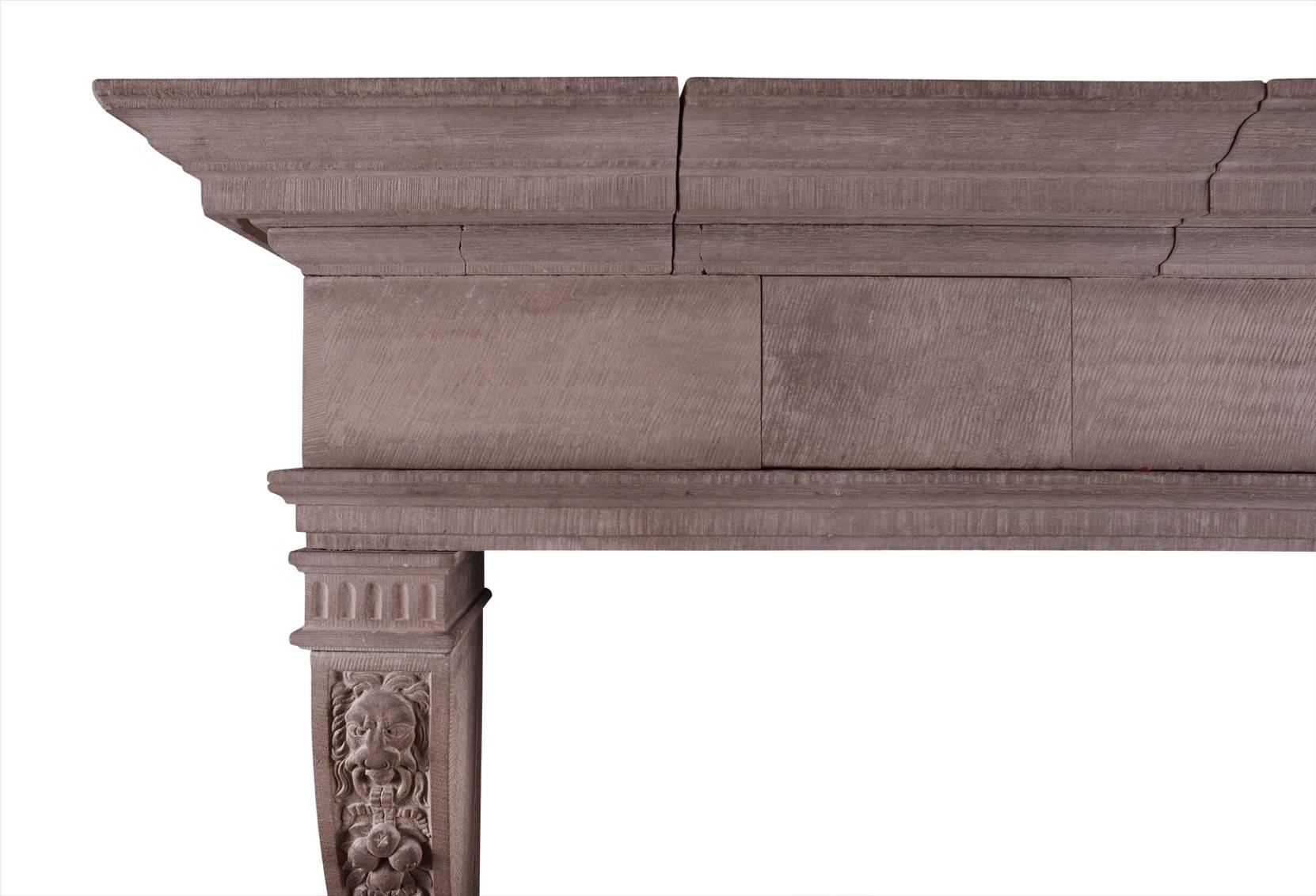 A large, rustic French limestone fireplace. The shaped jambs with carved fruit surmounted by tied ribbons and lion masks. Plain frieze with moulded shelf above. An impressive piece, circa 1900.

Measurements:
Shelf width: 1820 mm 71 5/8 in
Overall