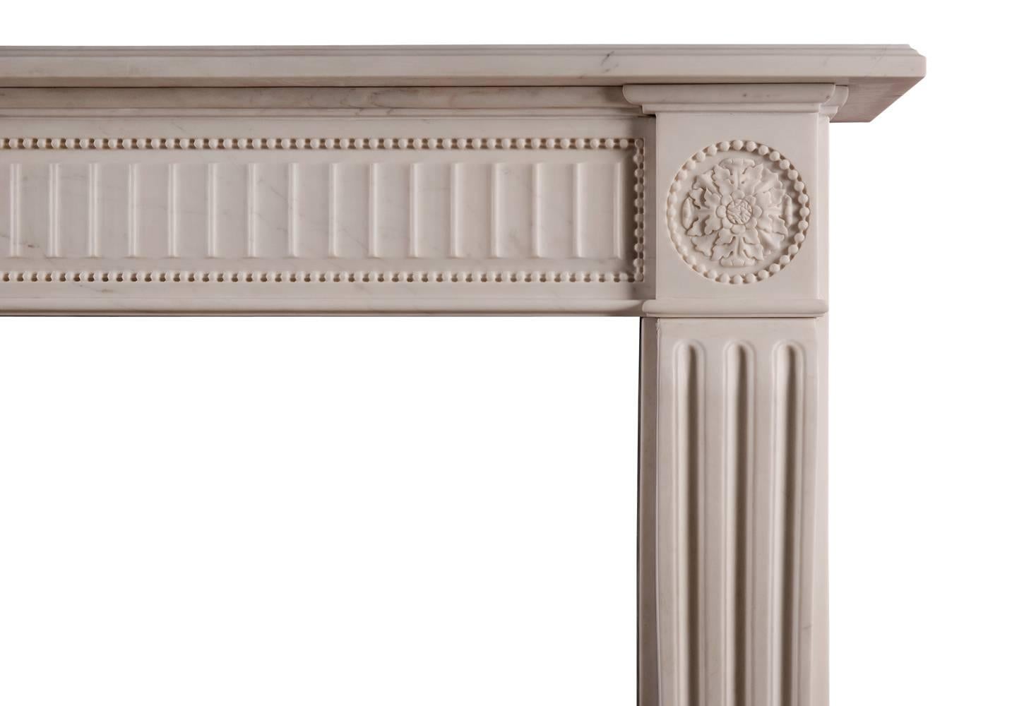 An English white marble fireplace in the Regency style. The fluted panelled frieze bordered by beads, shaped fluted jambs surmounted by carved round paterae and beading. A quality copy of an original piece.

Measures:
Shelf width -             1605