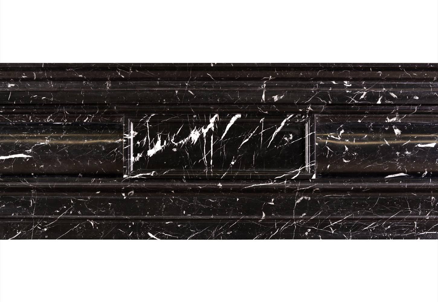 A stylish and well proportioned mid Georgian style fireplace in Nero Marquina marble. The barrel frieze with panelled centre and elegant moulded jambs and shelf. A striking black marble with white veining. A copy of an 18th century