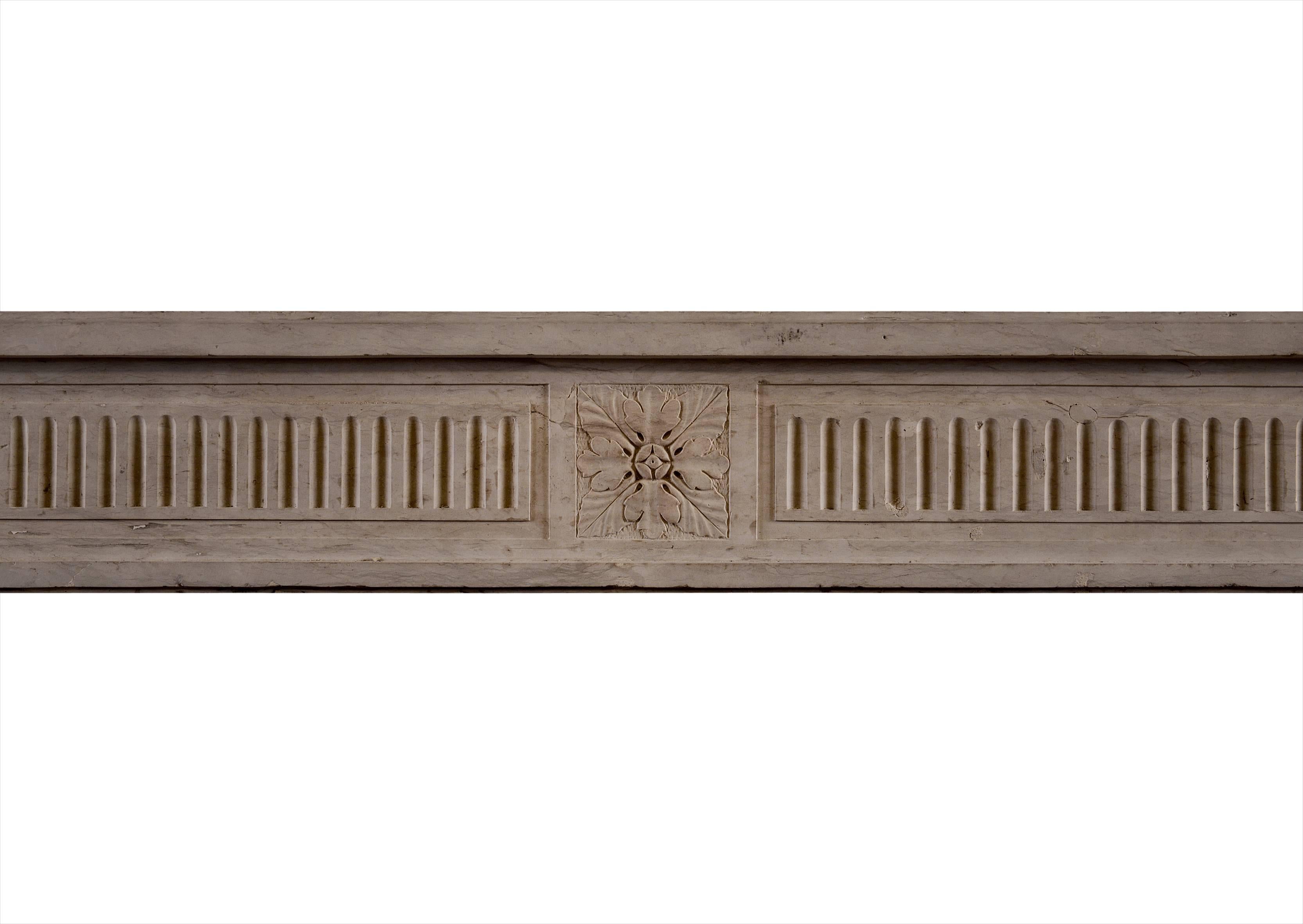 A fine quality Louis XVI Directoire limestone fireplace. The fluted frieze with carved rosette to centre, flanked by finely carved end paterae. The fluted jambs with diamond motif below. Very crisp carving of a hard, light limestone. Late 18th