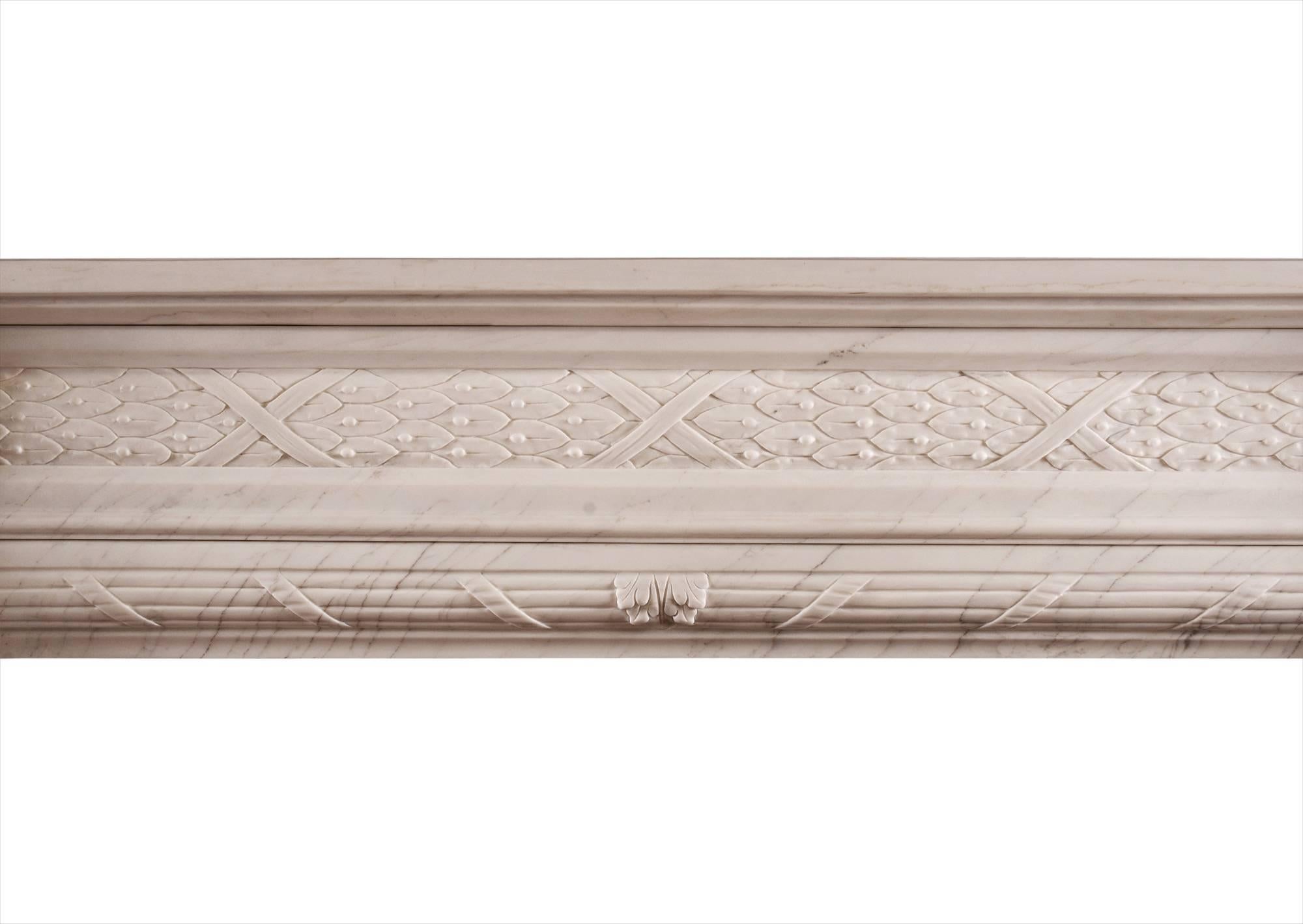 A good quality French Louis XVI style fireplace in white marble. The carved frieze with leaves bound by ribbons, the jambs with half rounded columns with delicate carving to flutes, the ingrounds with reeding wrapped in ribbons. The jambs are