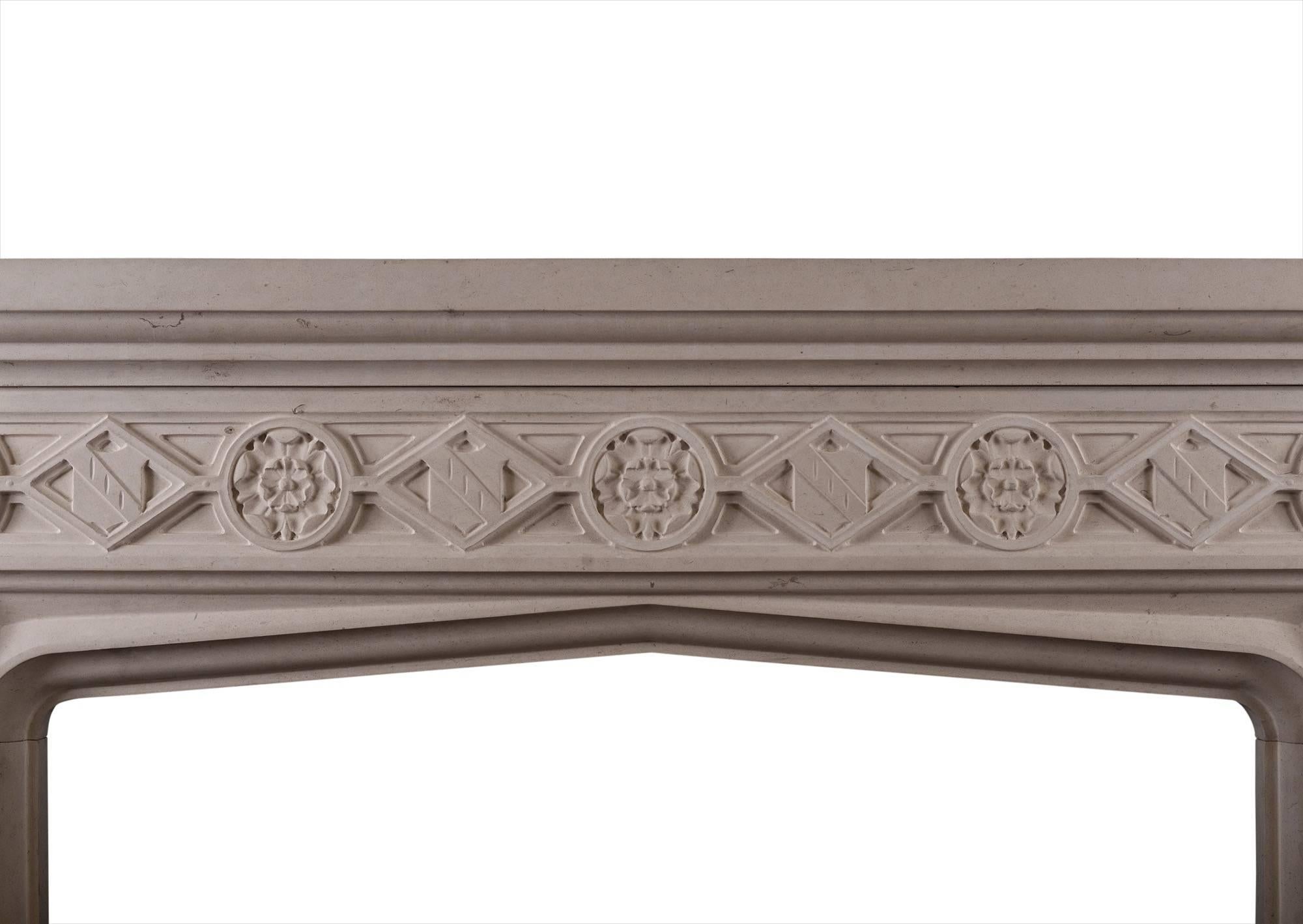 A carved limestone fireplace in the English Gothic style. The diamond shaped frieze with shields and Tudor roses with moulded jambs. Moulded shelf above. A copy of an earlier piece.

Measures: Shelf width 1572 mm 61 in
Overall height 1334 mm 52 ½
