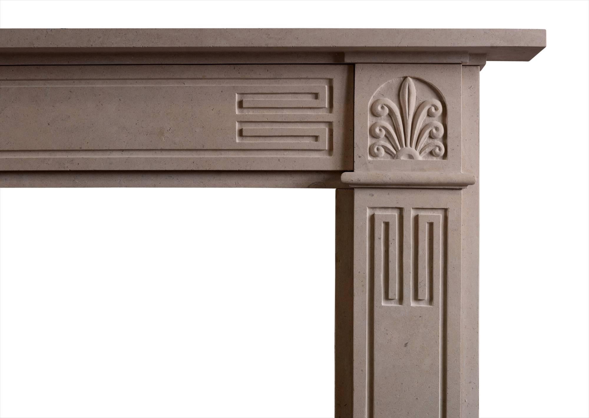 An English Bath stone fireplace in the Regency style. The panelled frieze and jambs with Greek key motif surmounted by Anthemion leaf. A good quality copy of an original piece.

Measures: 
Shelf Width:	1475 mm      	58 1/8 in
Overall Height:	1175 mm