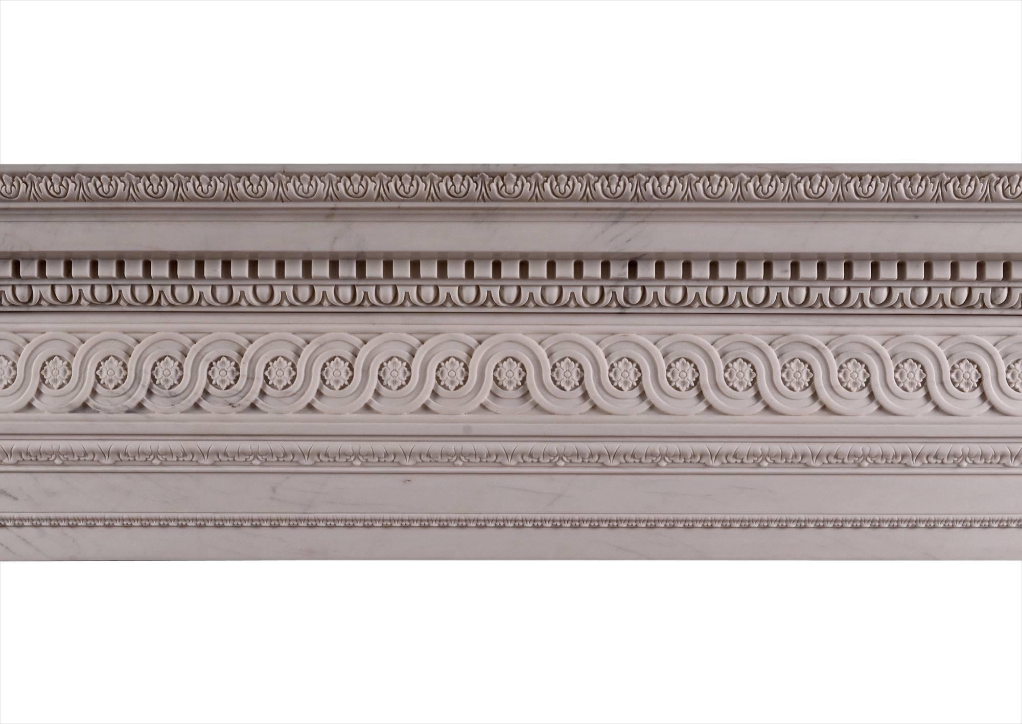 A late Georgian style fireplace carved in white marble. The jambs and frieze ornamented with a continuous band of guilloche enclosing rosettes and carved leaf mouldings. The shelf with acanthus leaf, egg and dart and dentil detailings. Based on a