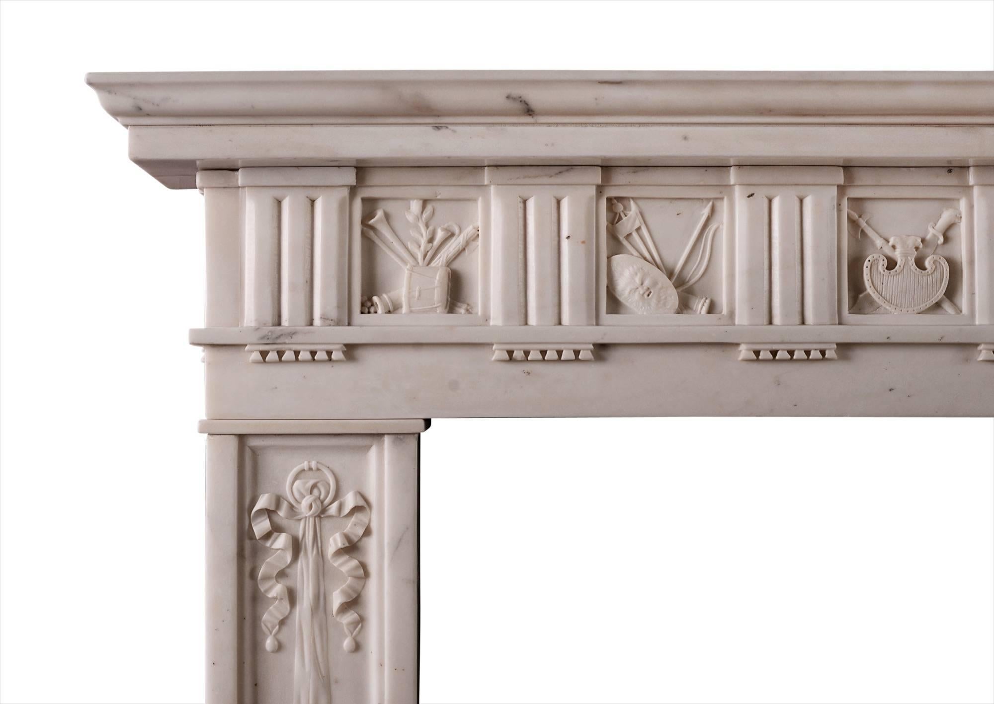 A fine quality English Regency fireplace in Italian statuary marble. The frieze with interspersed flutes and carved panels depicting pipes and other musical instruments. The jambs with cascading ribbons, amphorae, pipes and rosette paterae. Moulded