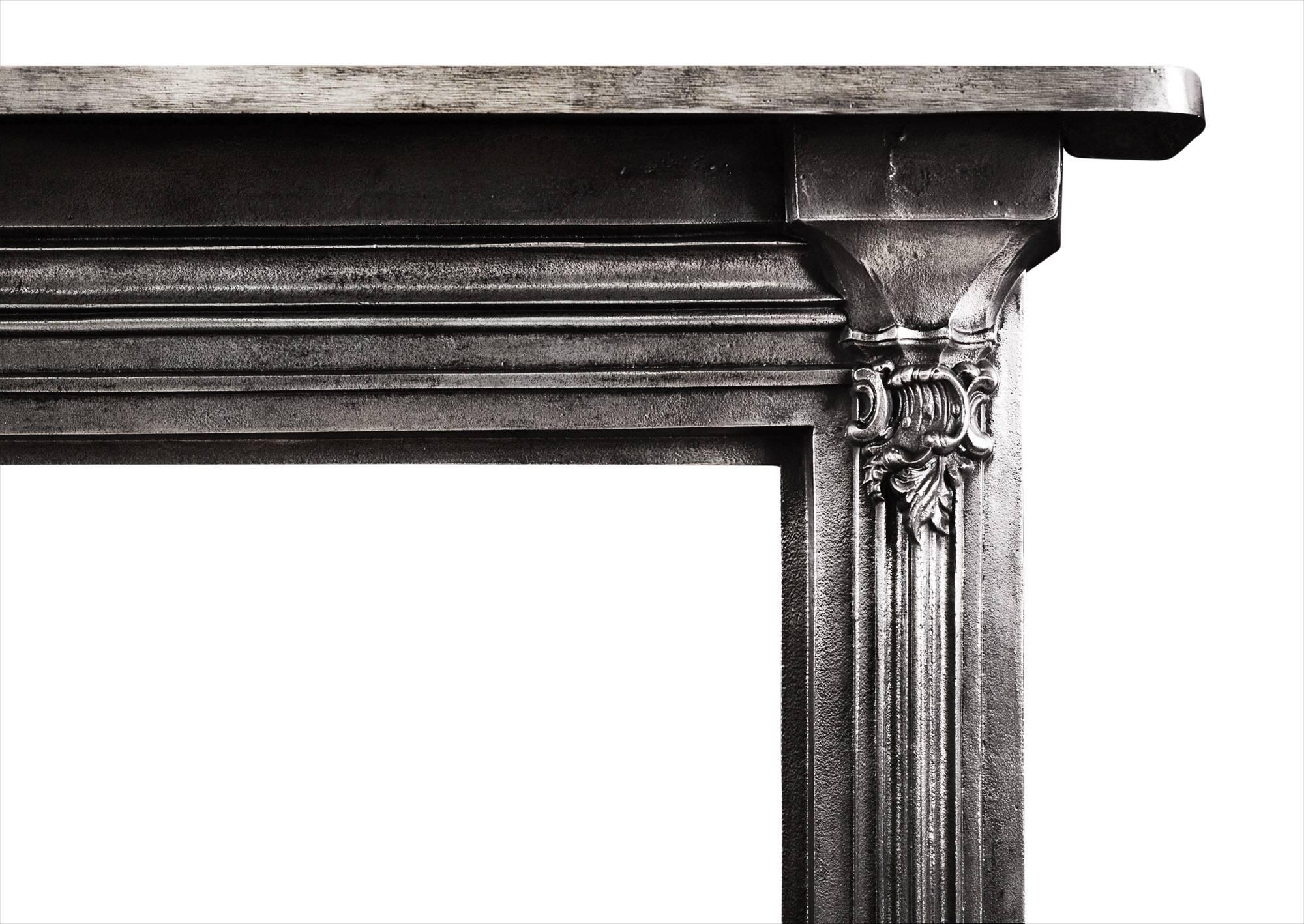 A polished cast iron fireplace. The jambs with embellishments to base, surmounted by reeding and shaped bracket of scrolls and foliage. Plain shelf above. English, circa 1900.

Measure: Shelf width 1000 mm 39 ? in
Overall height 1067 mm 42