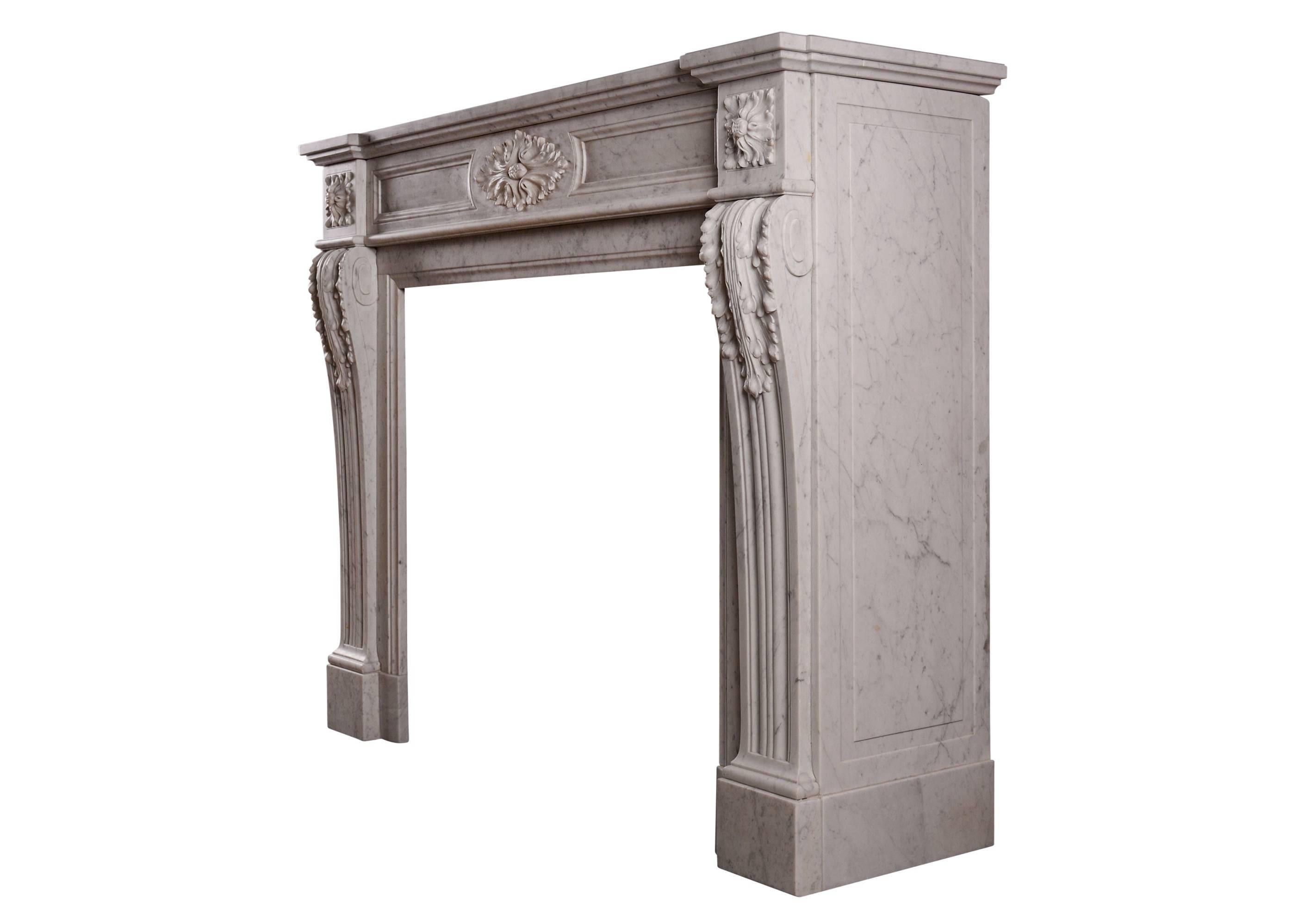 A French Louis XVI style fireplace in Carrara marble. The moulded jambs with acanthus leaves and scrolled returns, the frieze with carved oval paterae, moulded panels and square paterae to side blockings. Breakfront shelf, 19th century. Smaller