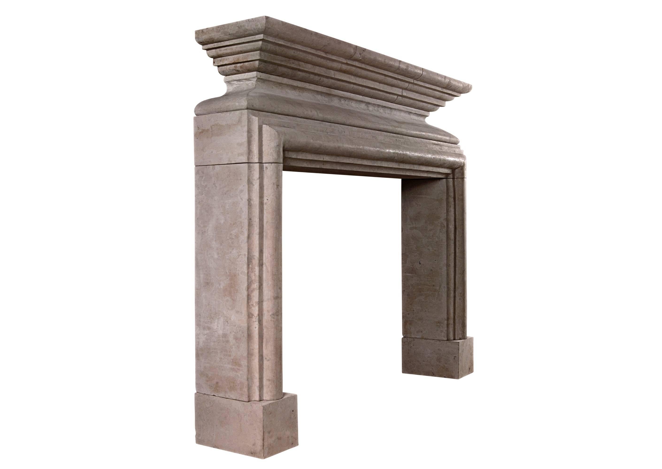 A French Louis XIII style limestone fireplace, with heavy architectural inner moulding, with shaped scalloped frieze, surmounted by moulded shelf in three pieces. A rustic piece.

N.B. May be subject to an extended lead time, please enquire for more