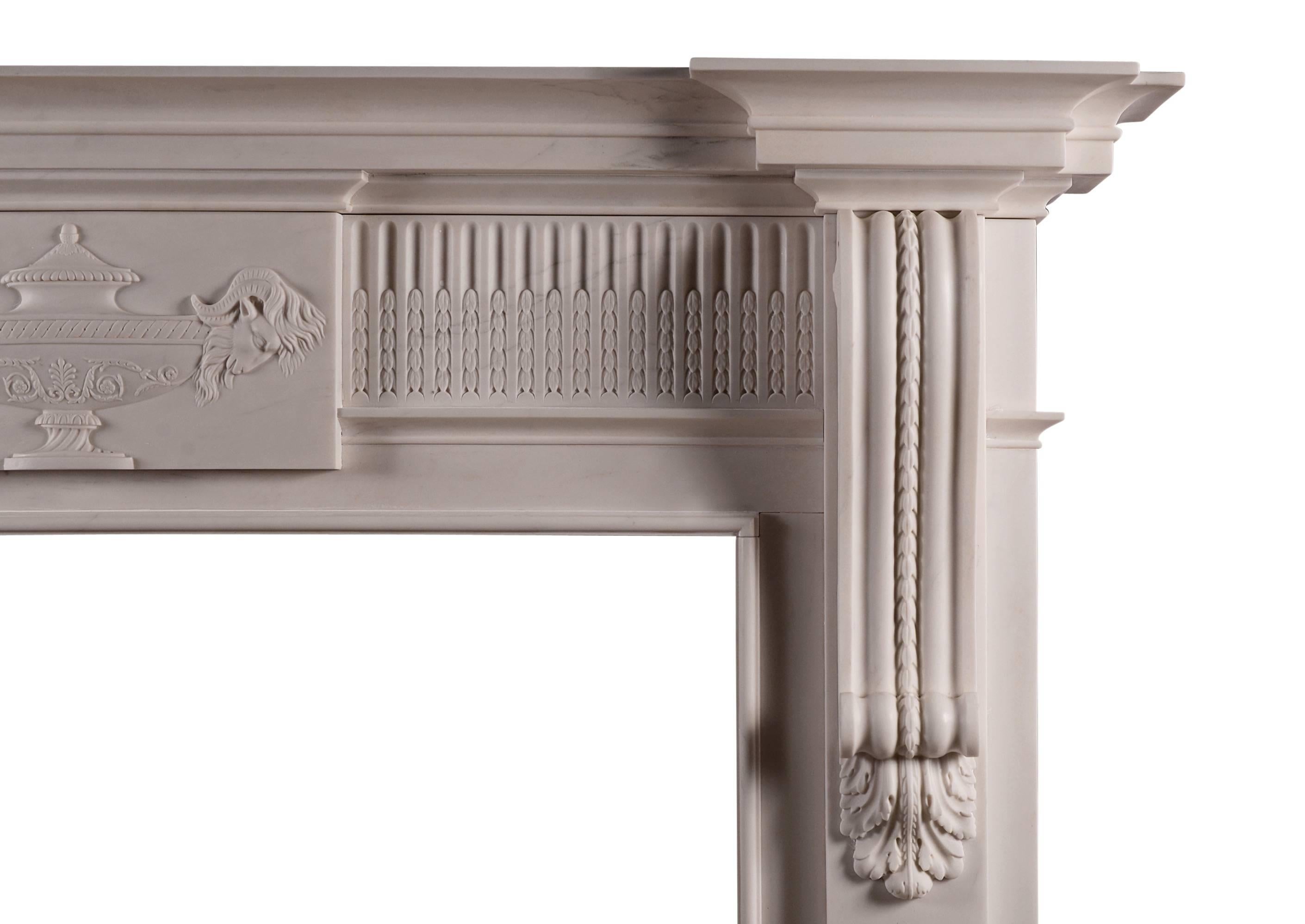 A finely carved late Georgian style fireplace in white marble. The jambs with well carved shaped brackets, fluted frieze with carved husks, with centre tablet of carved urn and rams heads. Breakfront moulded shelf. A fine copy of an original