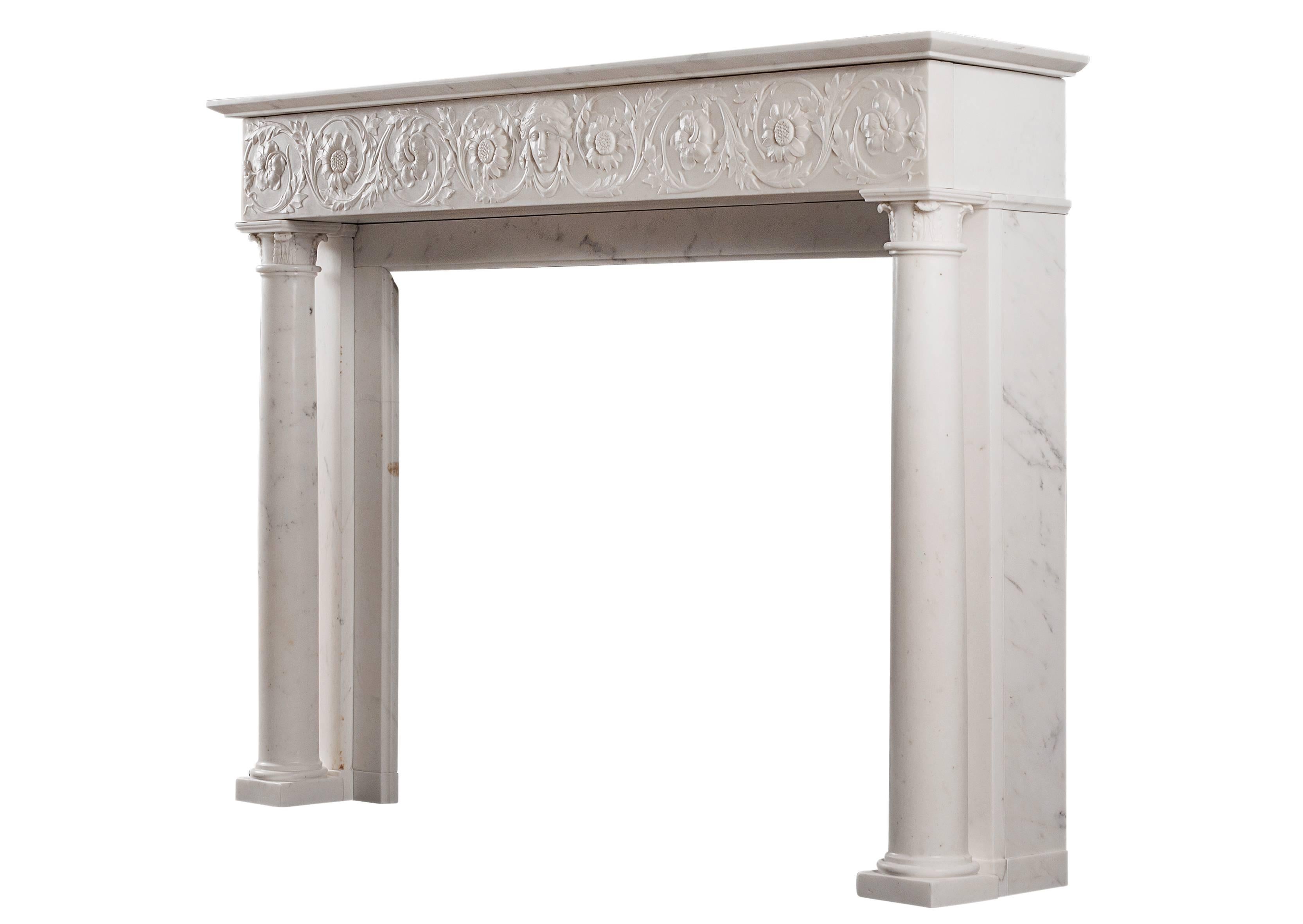 A fine quality antique Italian fireplace carved in Statuary marble. The running frieze delicately carved with sunflowers and foliage with female mask to centre. The full round tapering columns with carved turned over acanthus leaves to capitals,