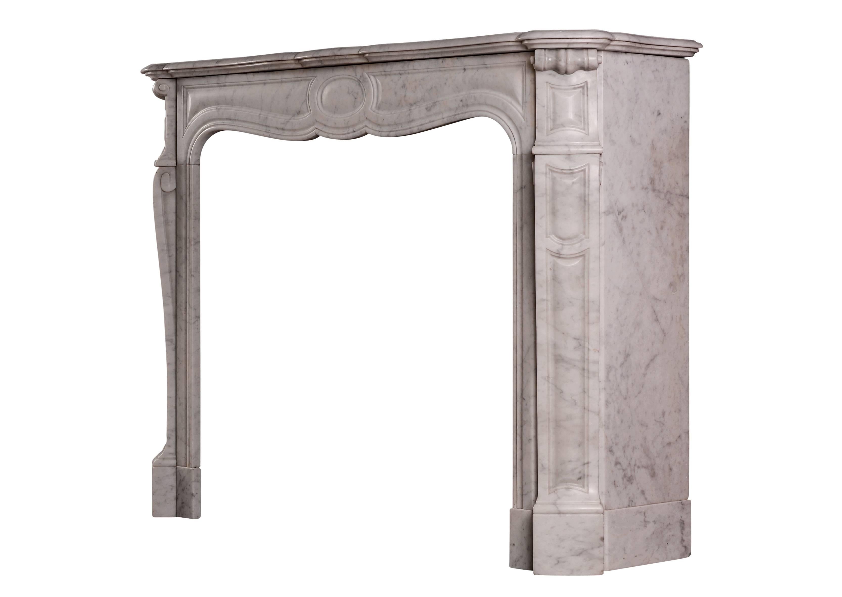 A 19th century French Louis XV style Pompadour fireplace in Carrara marble. The shaped, panelled jambs with scrolls to top, the frieze with panels and oval to centre. Shaped, moulded shelf. (Some staining to frieze.)

Measures: Shelf width 1229 mm