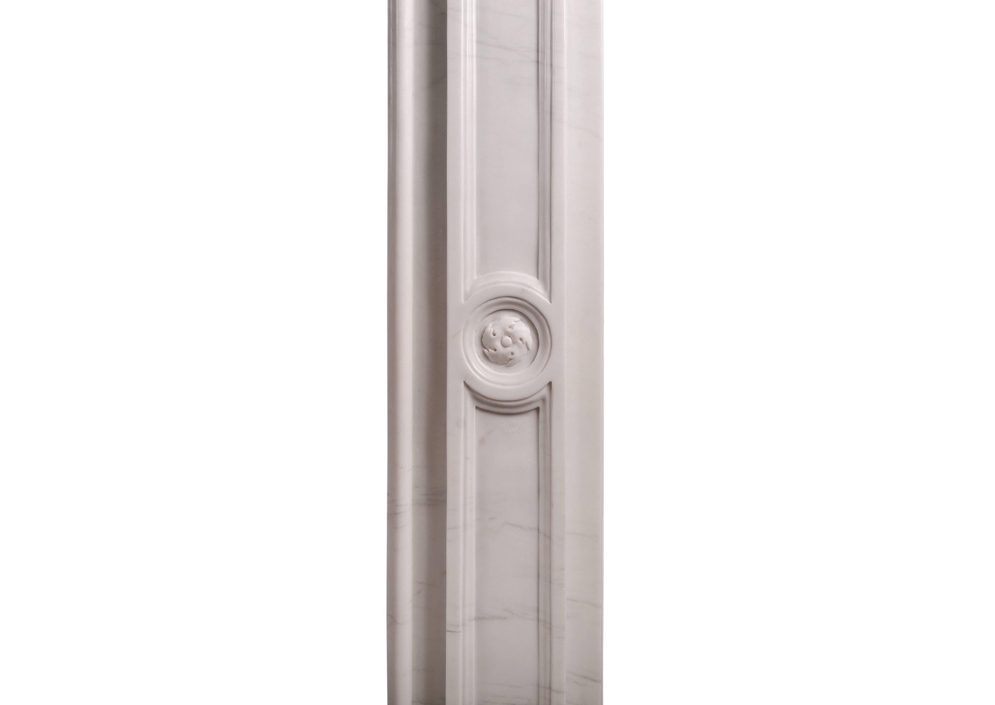 Une élégante cheminée en marbre blanc irlandais de style fin géorgien. La frise est ornée d'un panneau à patères tourbillonnées, entrecoupé de gouttes de campanules annelées, avec de courts détails cannelés au-dessous et une étagère moulée à fronton