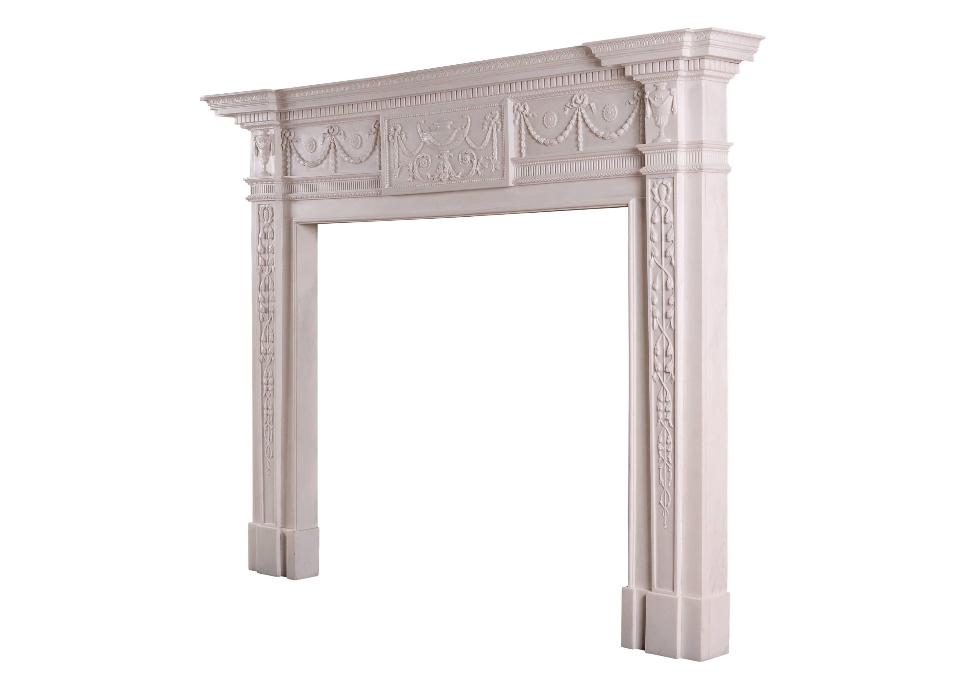 A fine quality English white marble fireplace in the late 18th century Robert Adam style. The frieze with carved centre block featuring urn and foliage with tied ribbons, the side panels with husks and drops connected with tied ribbons. The jambs