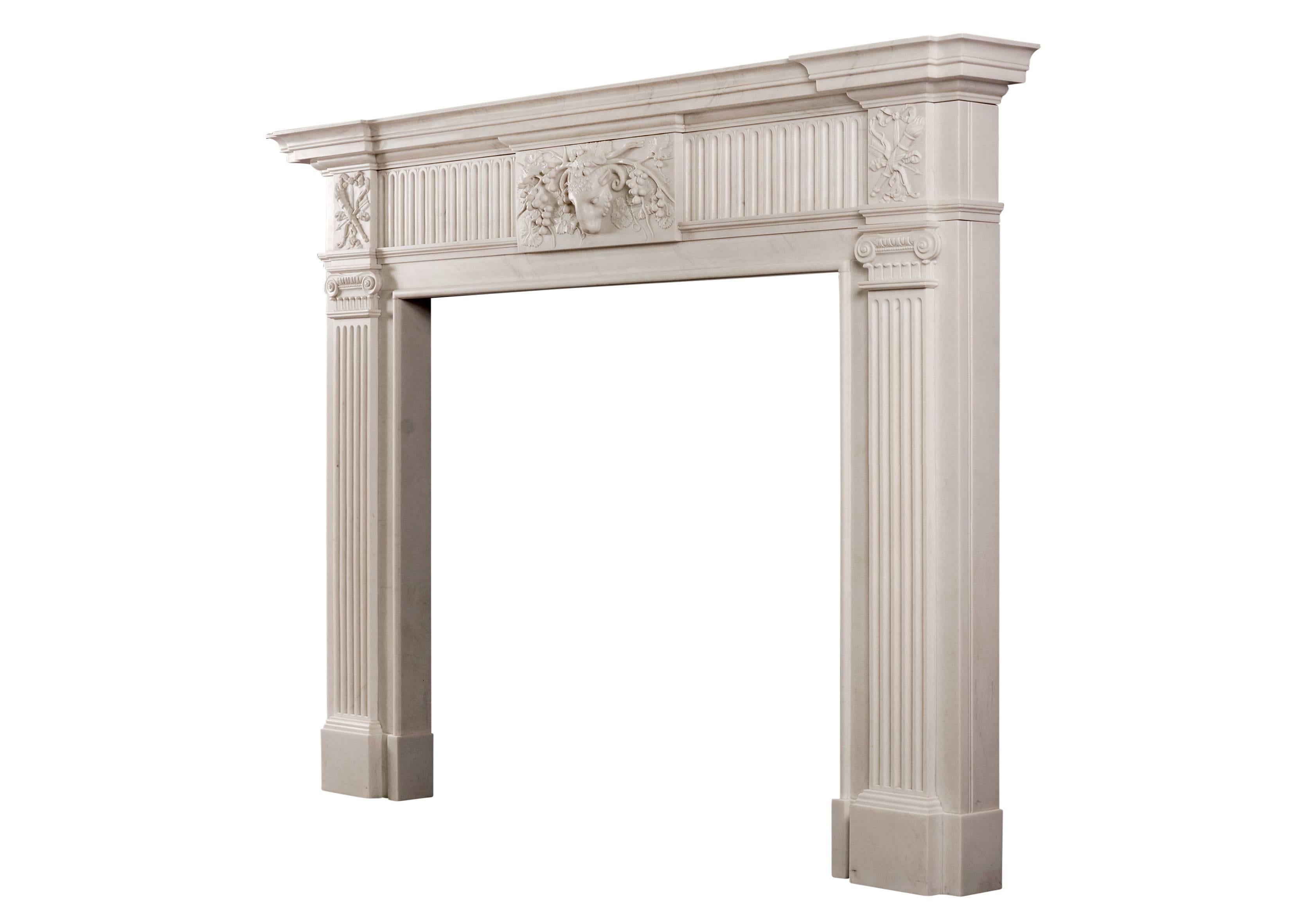 A fine quality English white marble fireplace in the manner of George III. The centre tablet with ram's head and vine leaves, juxtaposed with inlaid fluting. The fluted jambs surmounted by ionic capitals and quiver, arrow and ribbon side blocking.
