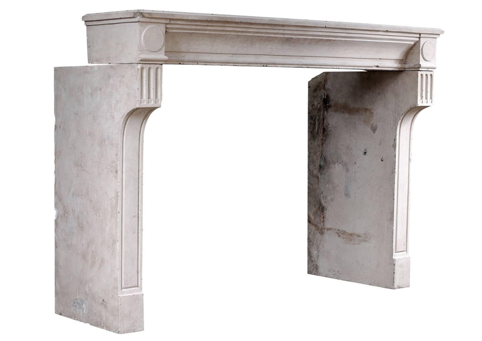 A rustic 18th century French Louis XVI limestone fireplace. The concave panelled frieze flanked by round end blockings, the deep, shaped panelled jambs with flutes above. Jambs intentionally left deep but could be reduced if required.

Measures: