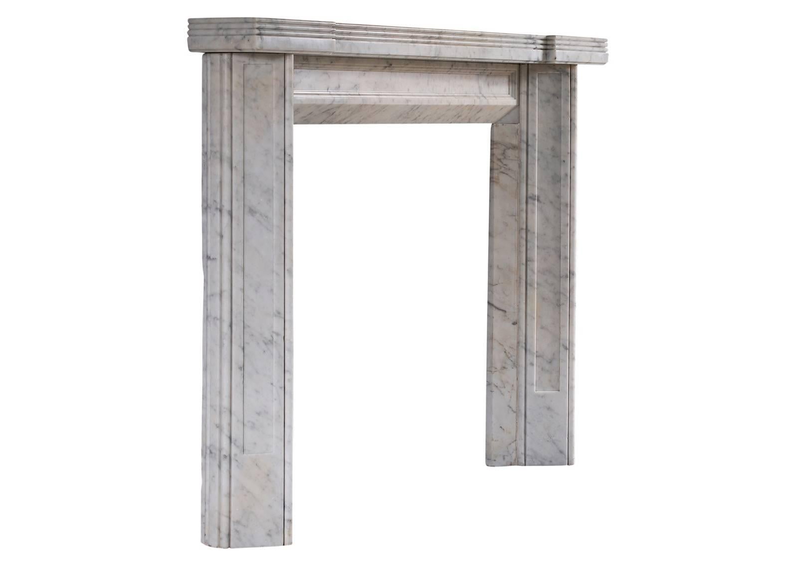 An unusual English Carrara marble fireplace from the Art Deco period. The triangular, panelled jambs surmounted by panelled frieze and reeded shelf. Early 20th century.

Measures: Shelf width 1384 mm 54 ½ in
Overall height 1060 mm 41 ¾