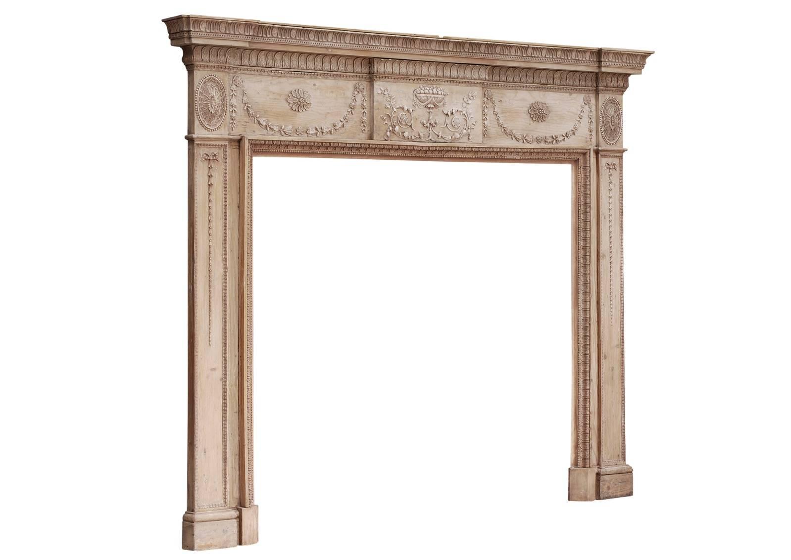 An 18th century pine and gesso fireplace. The centre with urn, fruit, scrolls, pateras and foliage. The frieze panels with swags, the side blockings with oval paterae. The jambs with Fine bellflower and ribbon drops. The shelf with acanthus leaf,