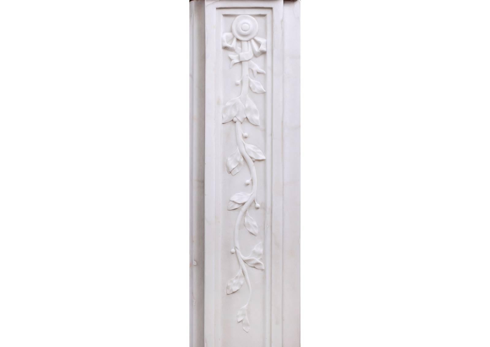 An elegant late 18th century period Louis XVI Statuary marble fireplace. The panelled frieze and jambs with trailing vine leaves, the frieze with centre motif of scrolls and leaves, and the jambs with tied ribbons to top.

Measures: 
Shelf width