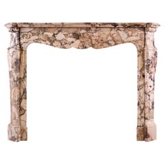 A French Louis XV style fireplace mantel in Brèche de Bénou marble