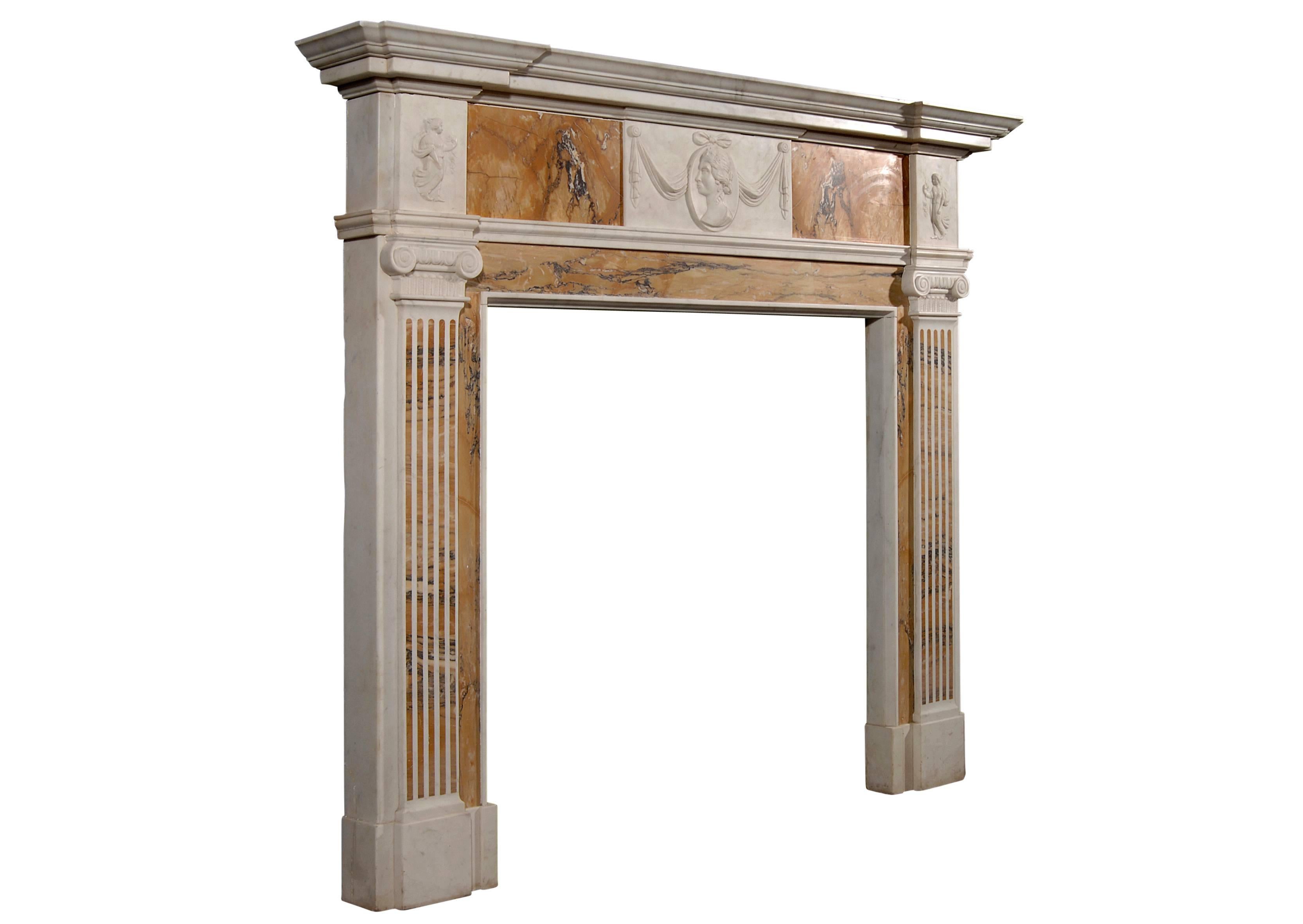 An English George III style Statuary and inlaid Sienna fireplace with center carving of drapery and female mask, putti to side blockings, and fluted jambs surmounted by Ionic capitals. Breakfront moulded shelf.

Shelf Width:	1765 mm      	69 1/2