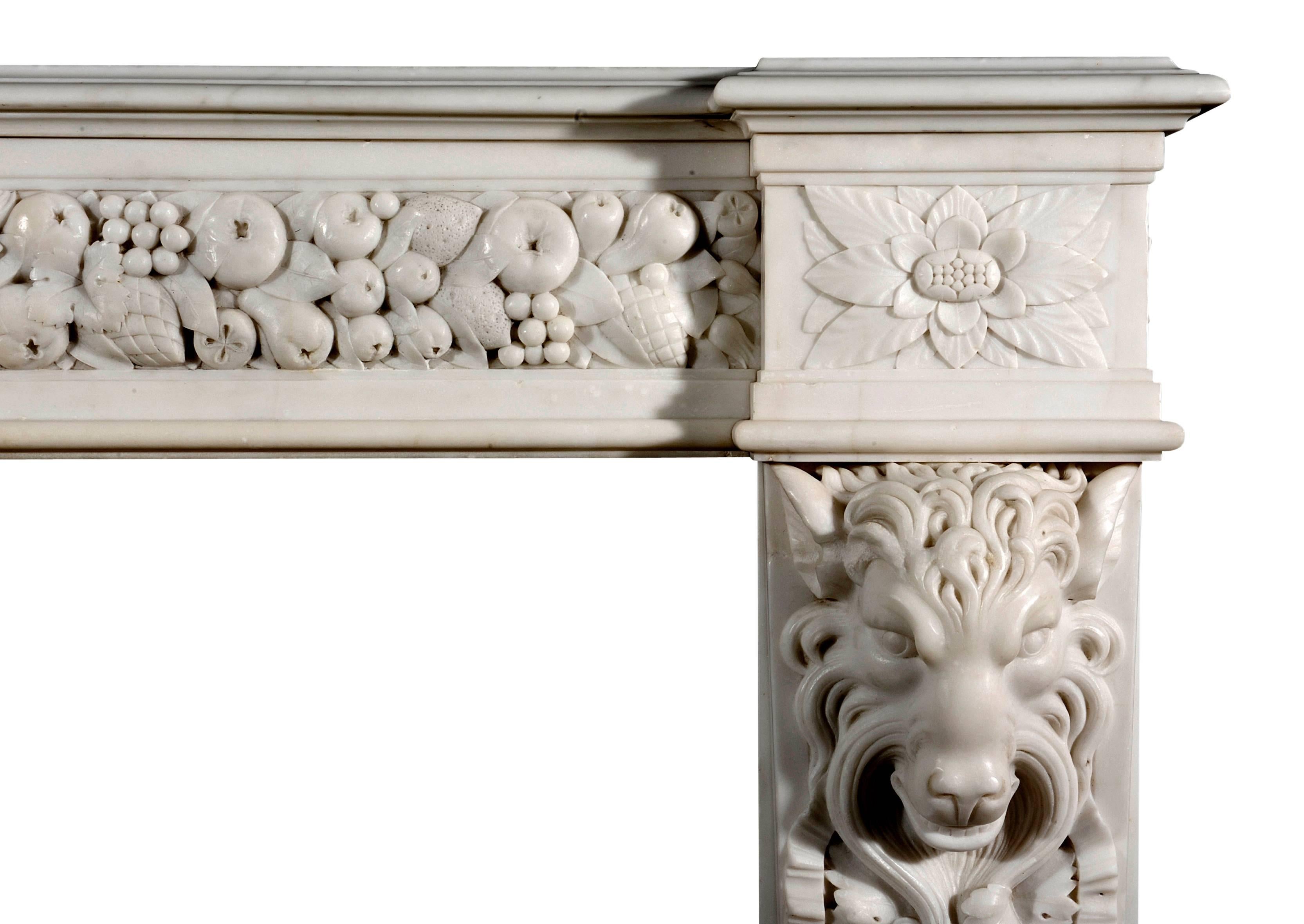 An impressive English mid-Victorian, circa 1850 statuary white marble fireplace. The frieze with carved fruit and leaves, the jambs with vine leaves and lion's masks, with carved leaf pateras above and to the sides. A rare and important piece.