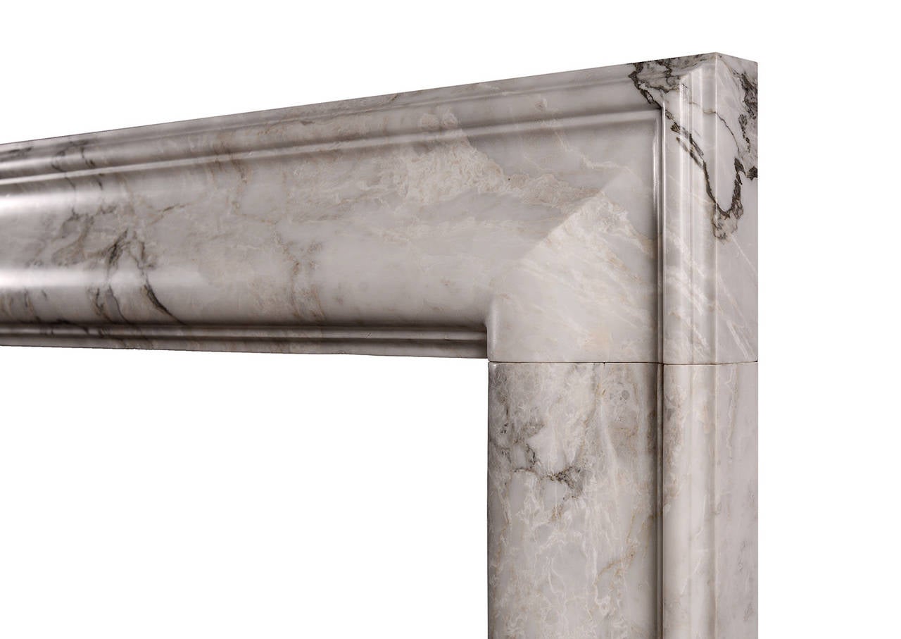 A stylish English moulded bolection fireplace in Arabescato marble, an Italian marble with a light background that is contrasted by olive-grey veining. A good quality copy of the Queen Anne design. Could be made to any size and in other materials if
