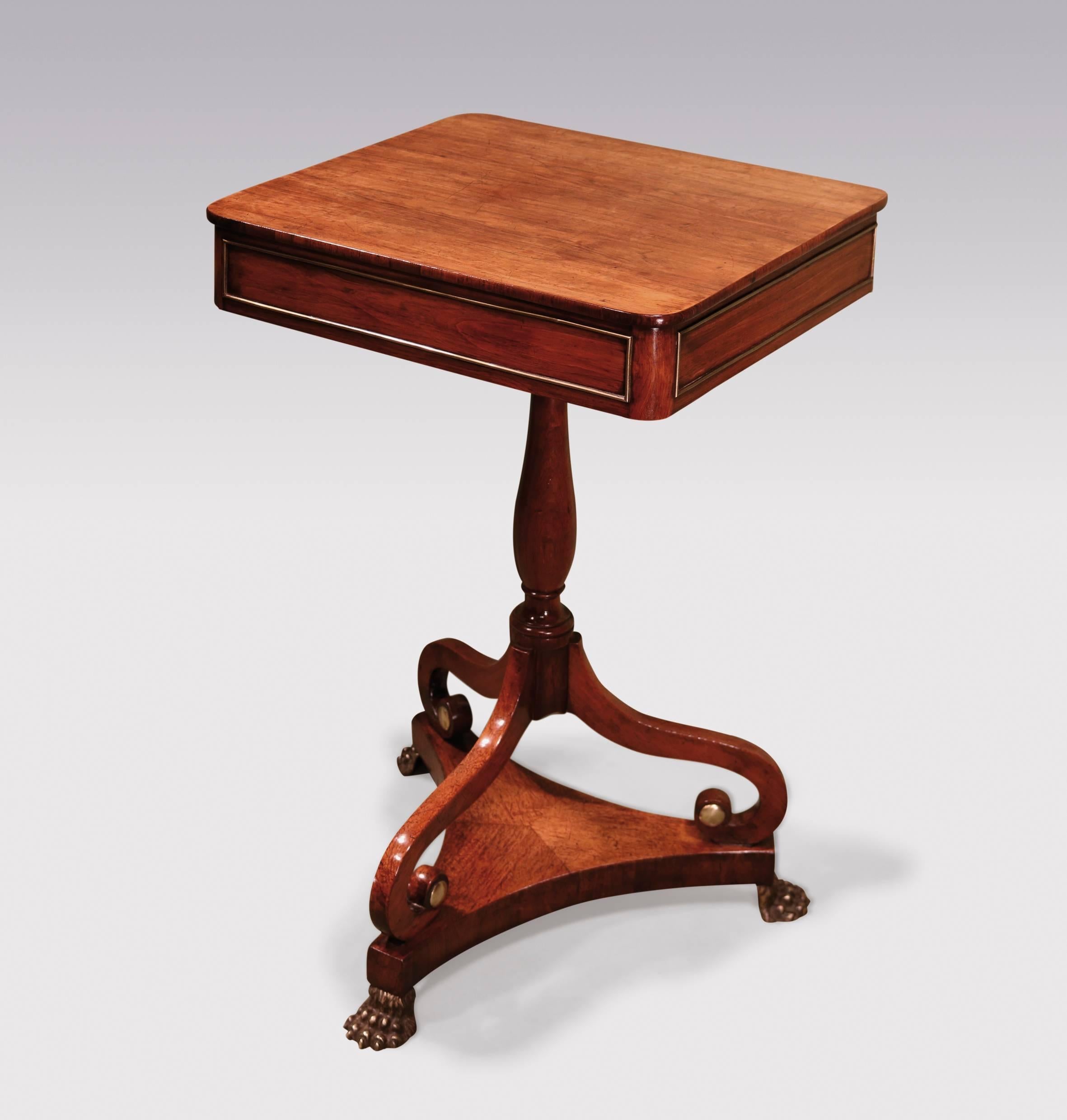 An unusual early 19th century Regency period faded rosewood occasional table, having rectangular top above brass cockbeaded frieze, raised on turned stem and scrolled tripod base, ending on further triform platform with brass lion's paw feet.