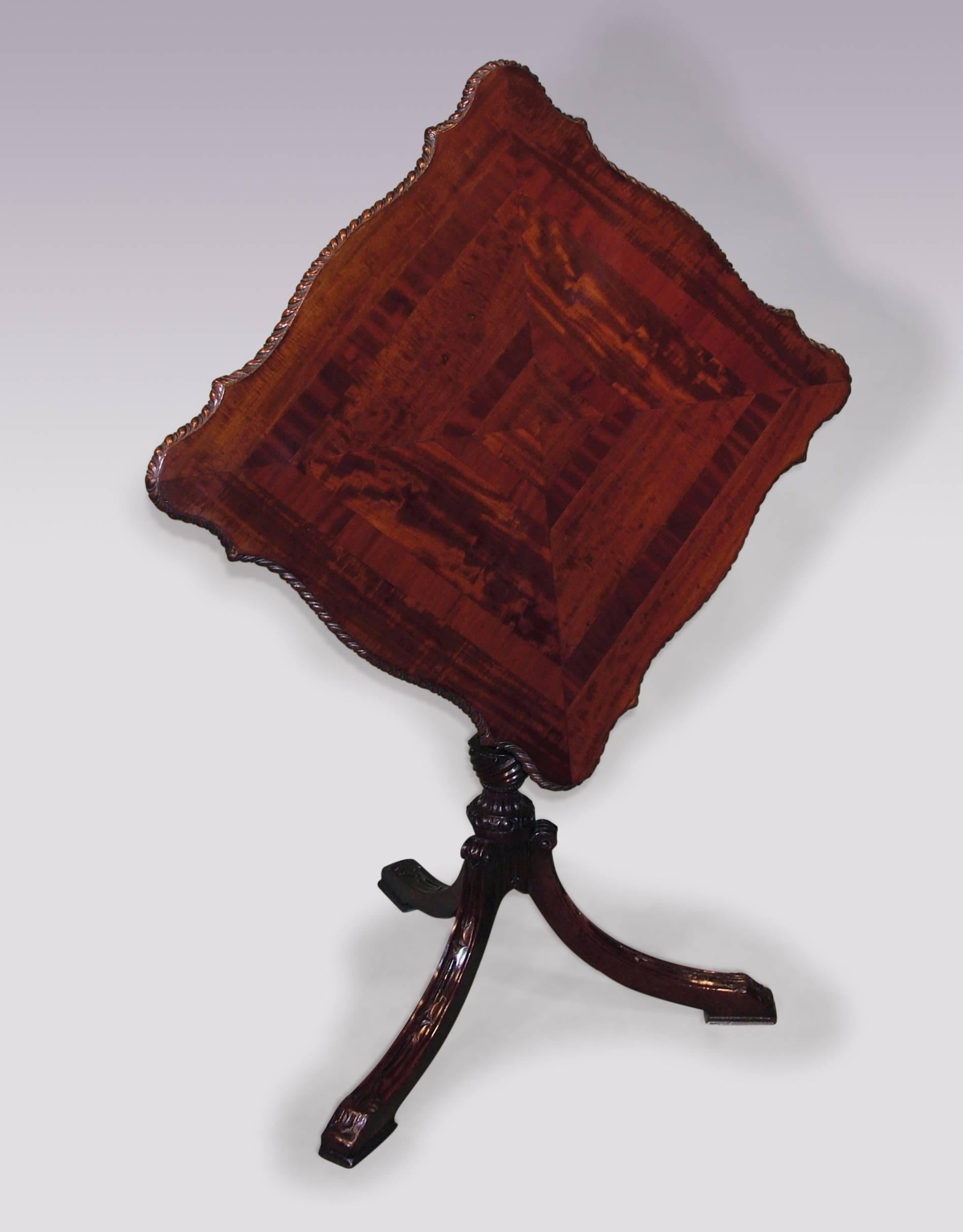 A mid-18th century Chippendale period mahogany tripod table, having unusual serpentine top with crossbanded panelling and carved gadrooned edge, raised on fluted spiral twist stem, supported on diamond and acanthus carved splayed tripod legs, ending