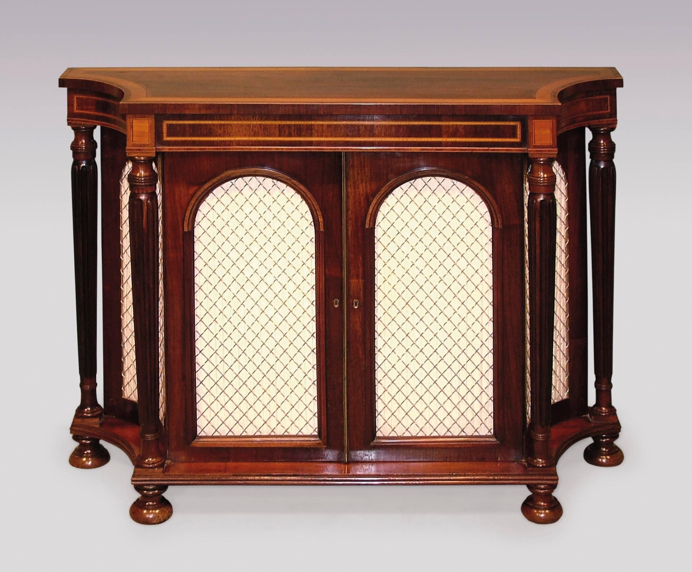 An early 19th century Regency period rosewood chiffonier of attractive small proportions, having satinwood and tulipwood crossbanded concave top, above matching frieze, with two real and two dummy silk pleated brass grille doors below, flanked by