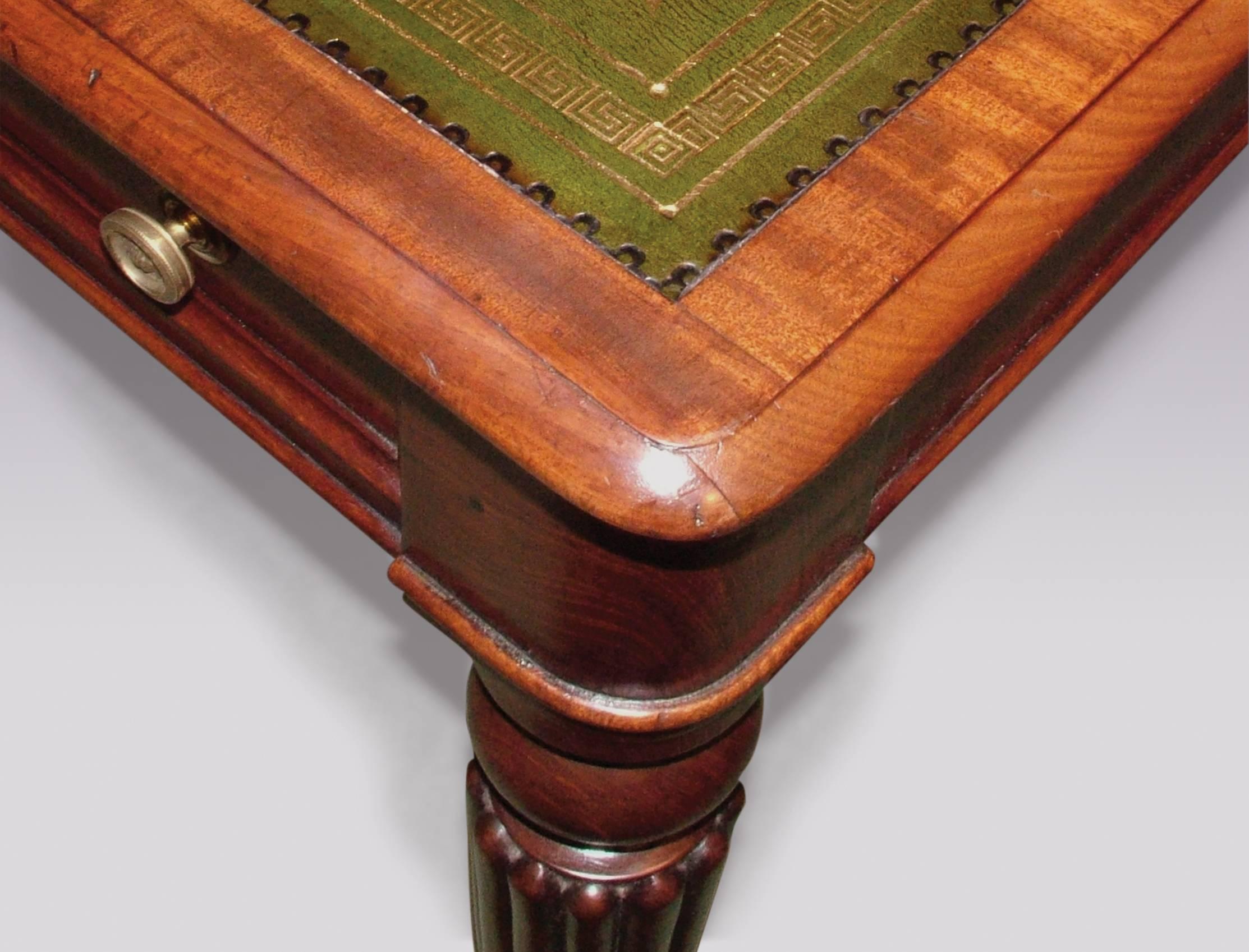 An early 19th century William IV period mahogany writing table, having green and gilt tooled leather crossbanded and moulded edged top, above three real and three dummy panelled drawers supported on ring-turned reeded tapering legs ending on brass