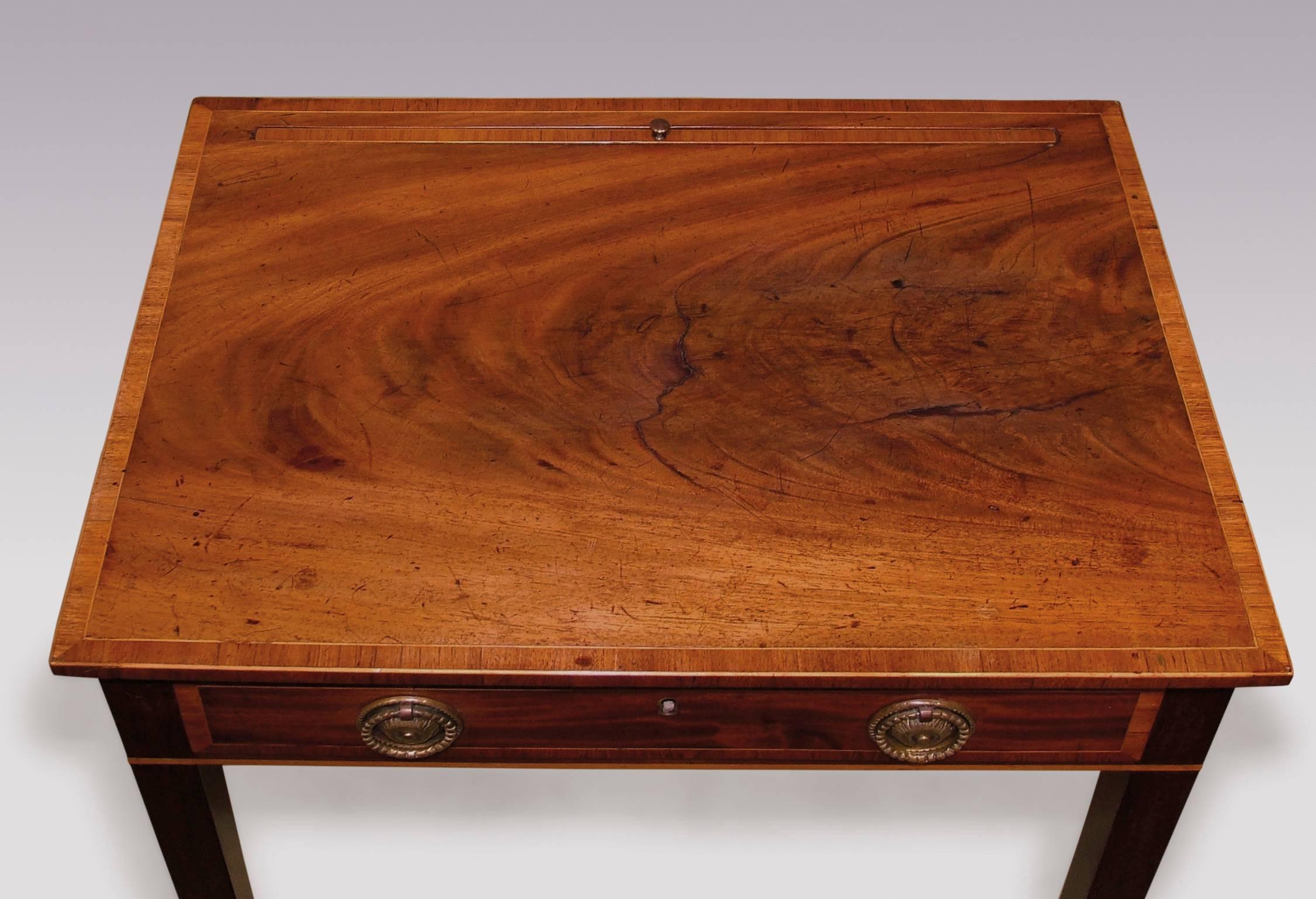 A George III period well figured mahogany lamp table, tulipwood crossbanded throughout, having rectangular top with lift up slide, above frieze drawer, supported on square tapering legs.