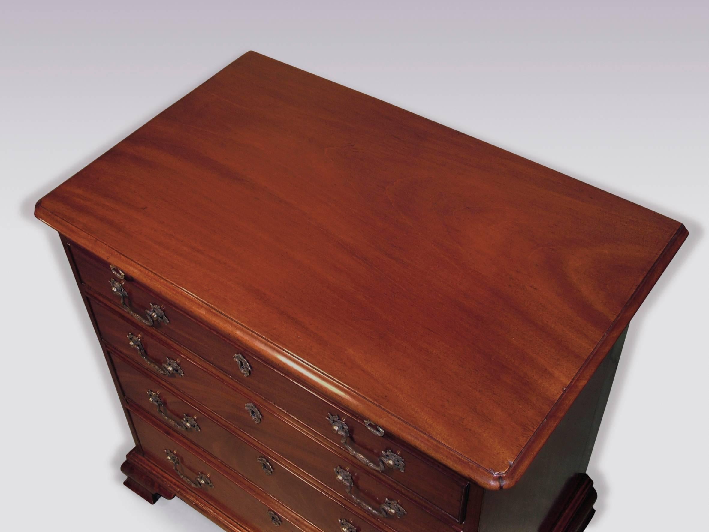 A mid-18th century George III period mahogany chest, of attractive small proportions, having moulded edge top with re-entrant corners, above brushing slide with four cockbeaded graduated drawers, retaining original handles, supported on ogee bracket