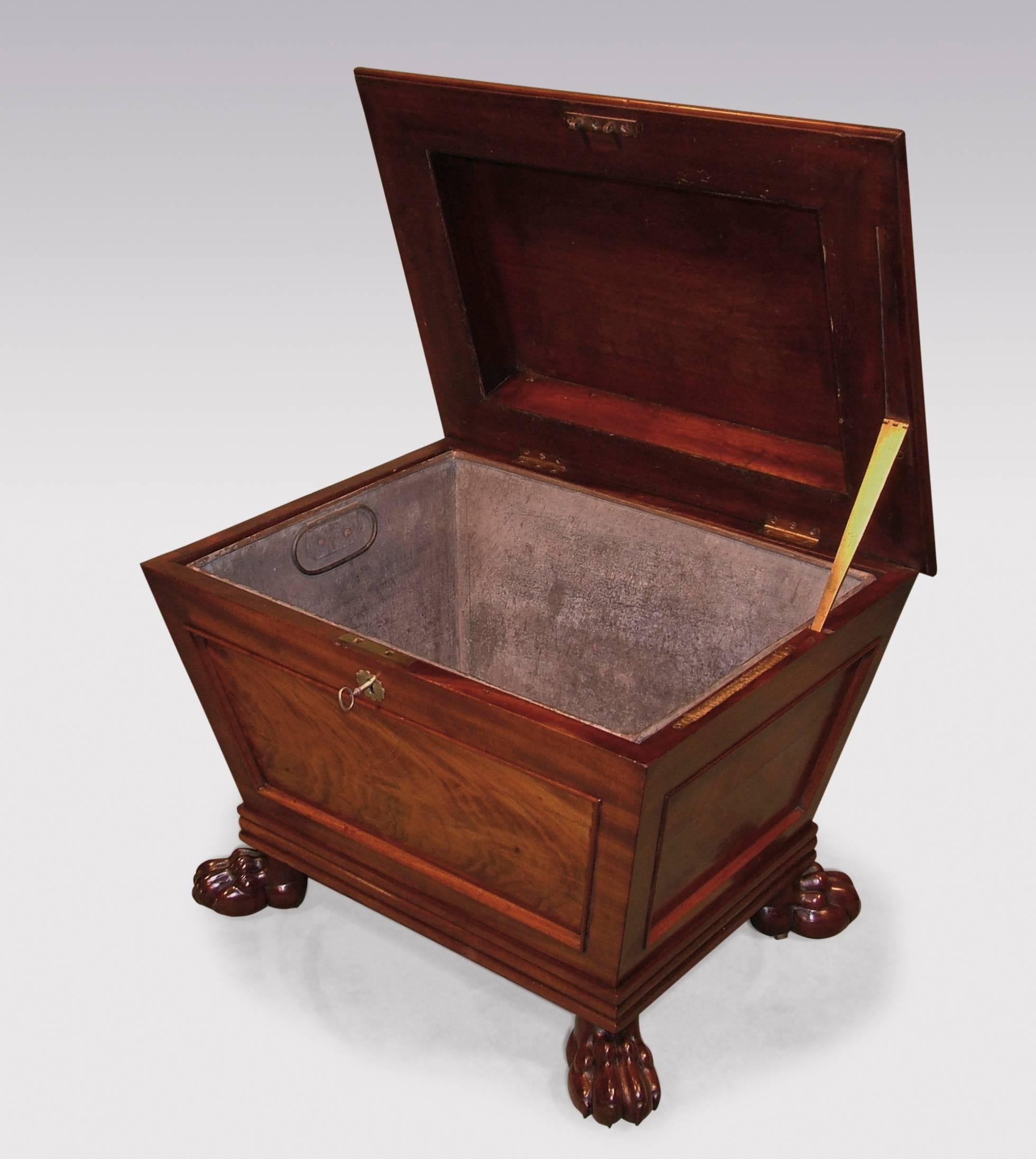 An early 19th century Regency period flame figured mahogany sarcophagus-shaped Cellarette, of attractive small proportions, having moulded edge lid enclosing replacement liner, supported on carved lions paw feet with concealed castors.