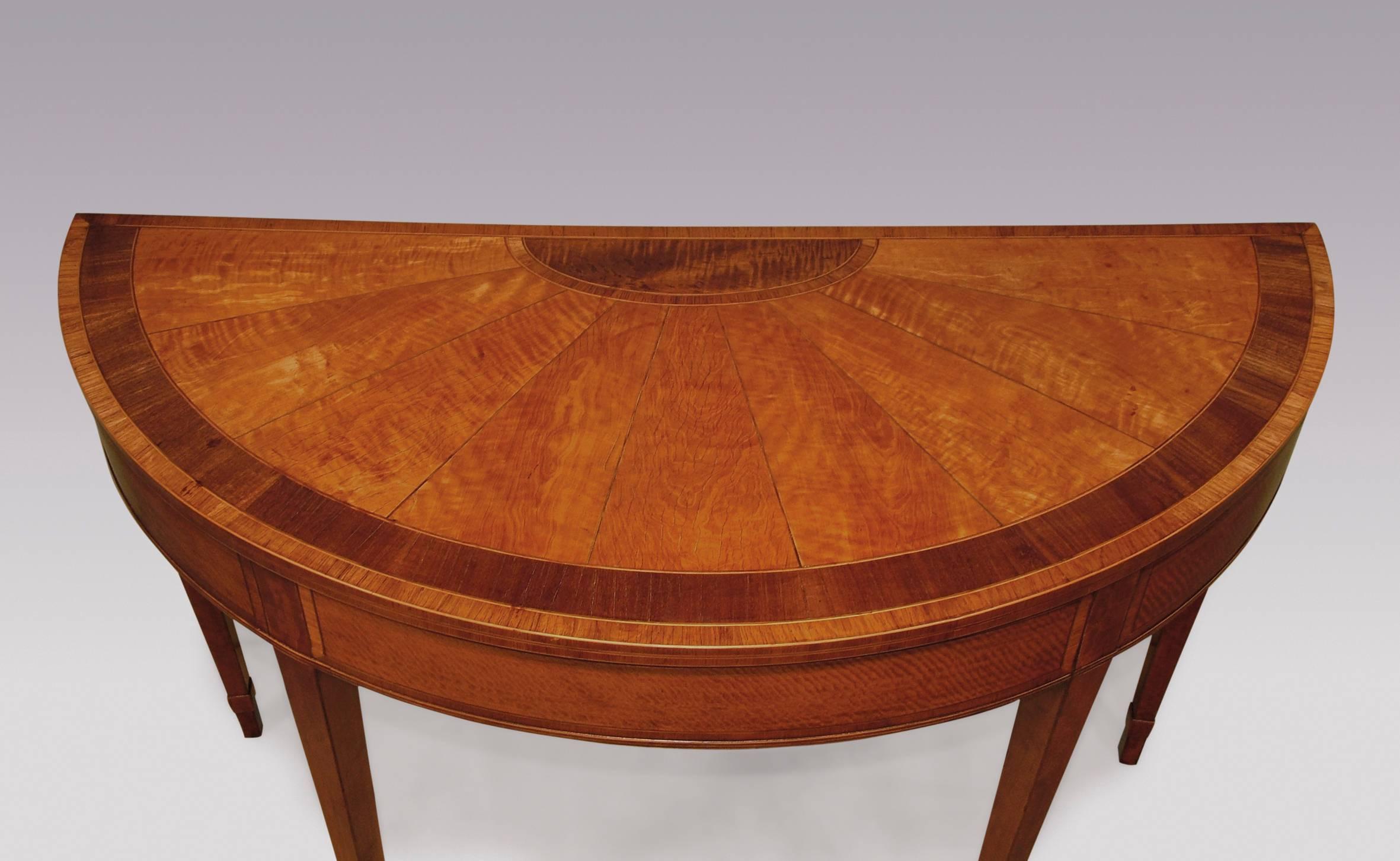 A late 18th century Sheraton period demilune satinwood card table, boxwood and ebony line inlaid and tulipwood crossbanded throughout, having rosewood crossbanded segmented top with central panel to the rear, above panelled frieze, supported on