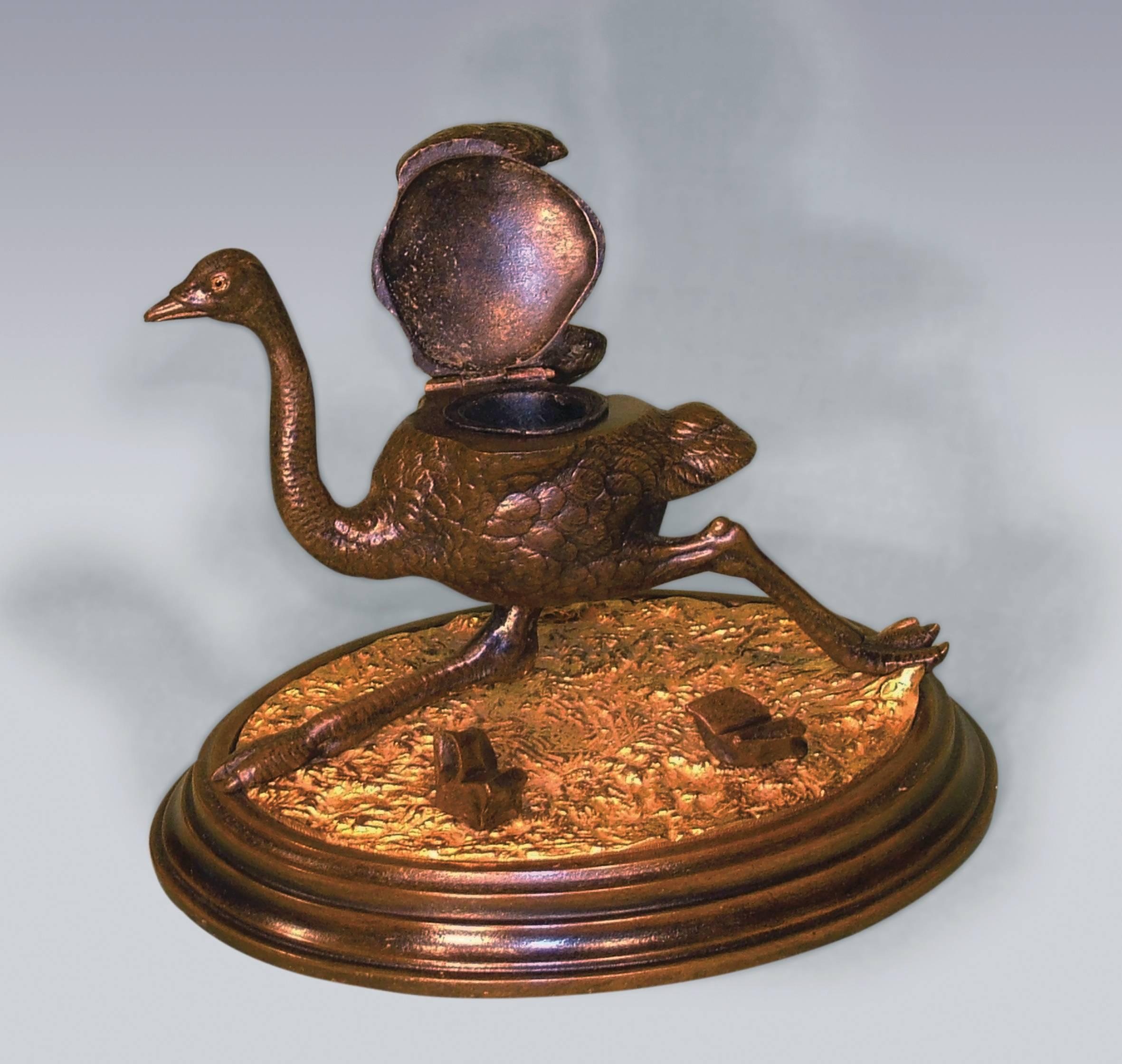 An unusual 19th century bronze and ormolu Inkwell, in the form of running Ostrich with hinged lid, mounted on oval base with fallen rocks for use as a pen holder, ending on moulded plinth base.
