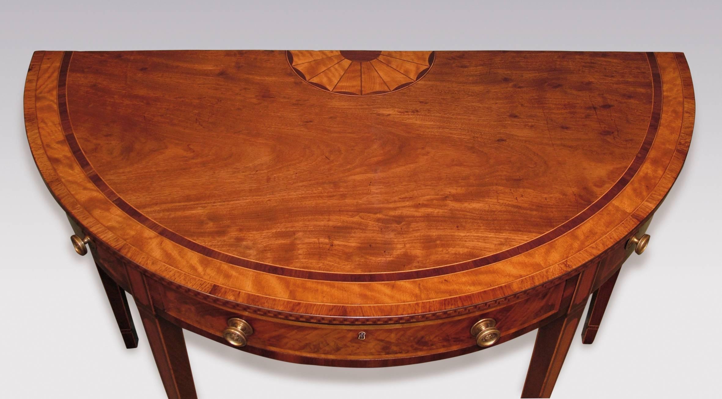 A late 18th century sheraton period mahogany side table, having purple heart, satinwood and tulipwood crossbanded half round top with satinwood fan inlay to the rear and Greek key pattern to the edge. The Table having one real and two dummy